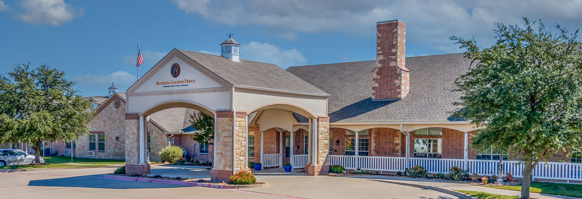 Front view of Bethesda Gardens Frisco Assisted Living building with brick exterior and covered entrance.