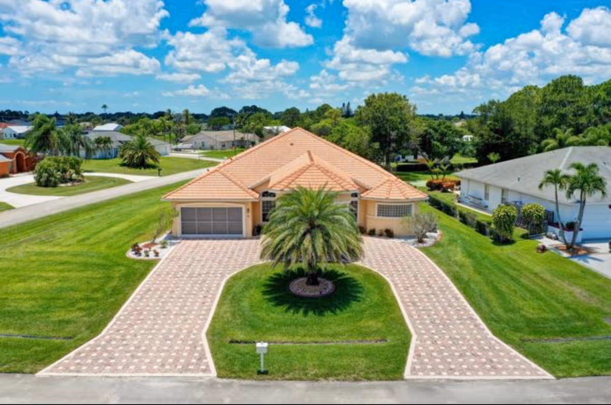 Aerial view of Avalon Family Resort front exterior with circular palm island and brick driveway.