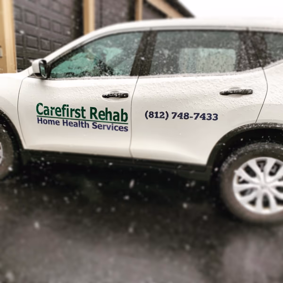 White vehicle with Carefirst Rehab branding parked outside in snowy weather.