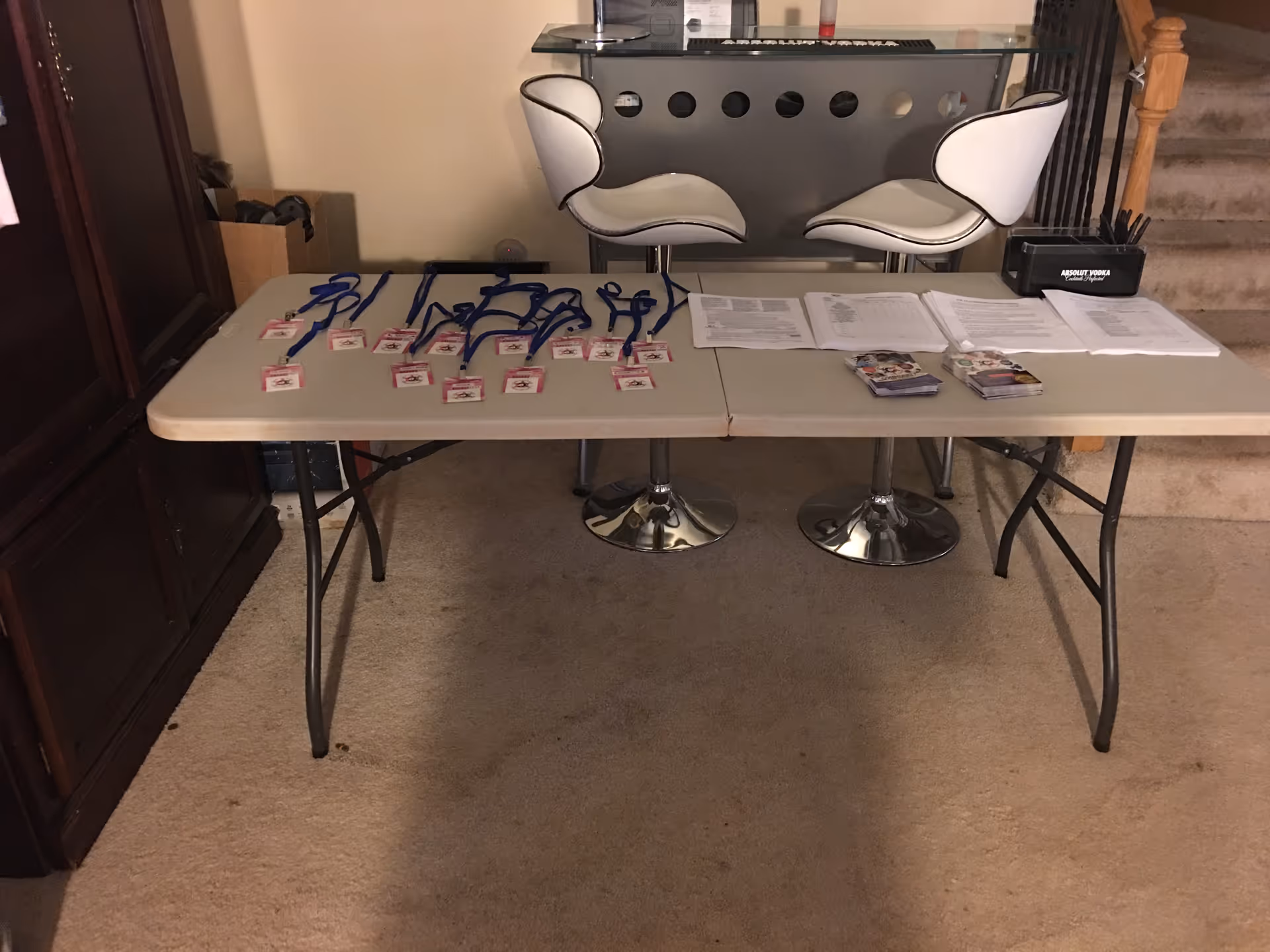 Registration table with lanyards, papers, and brochures in an interior hallway.