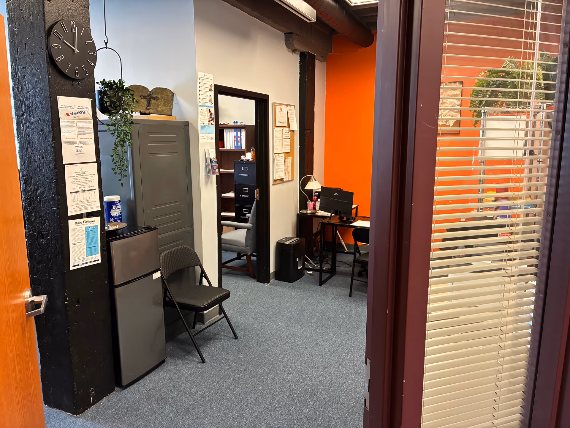 Interior office area with desk, filing cabinets, chairs, and bulletin boards.