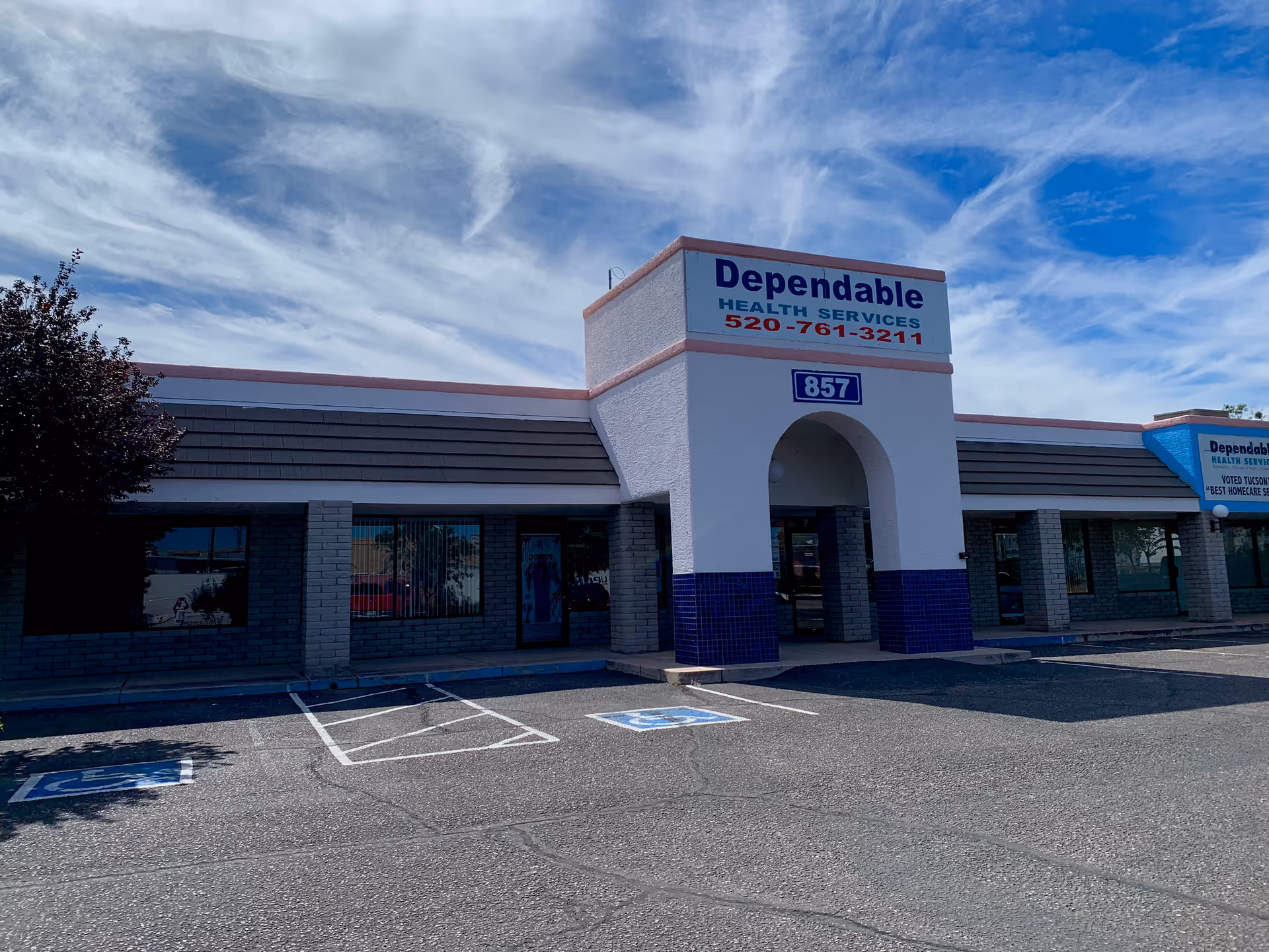 Front exterior of a Dependable Health Services facility with arched entrance and parking.