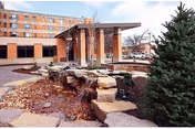 Exterior view of Meth-Wick Community building with brick facade, covered entrance, and landscaped rock garden.