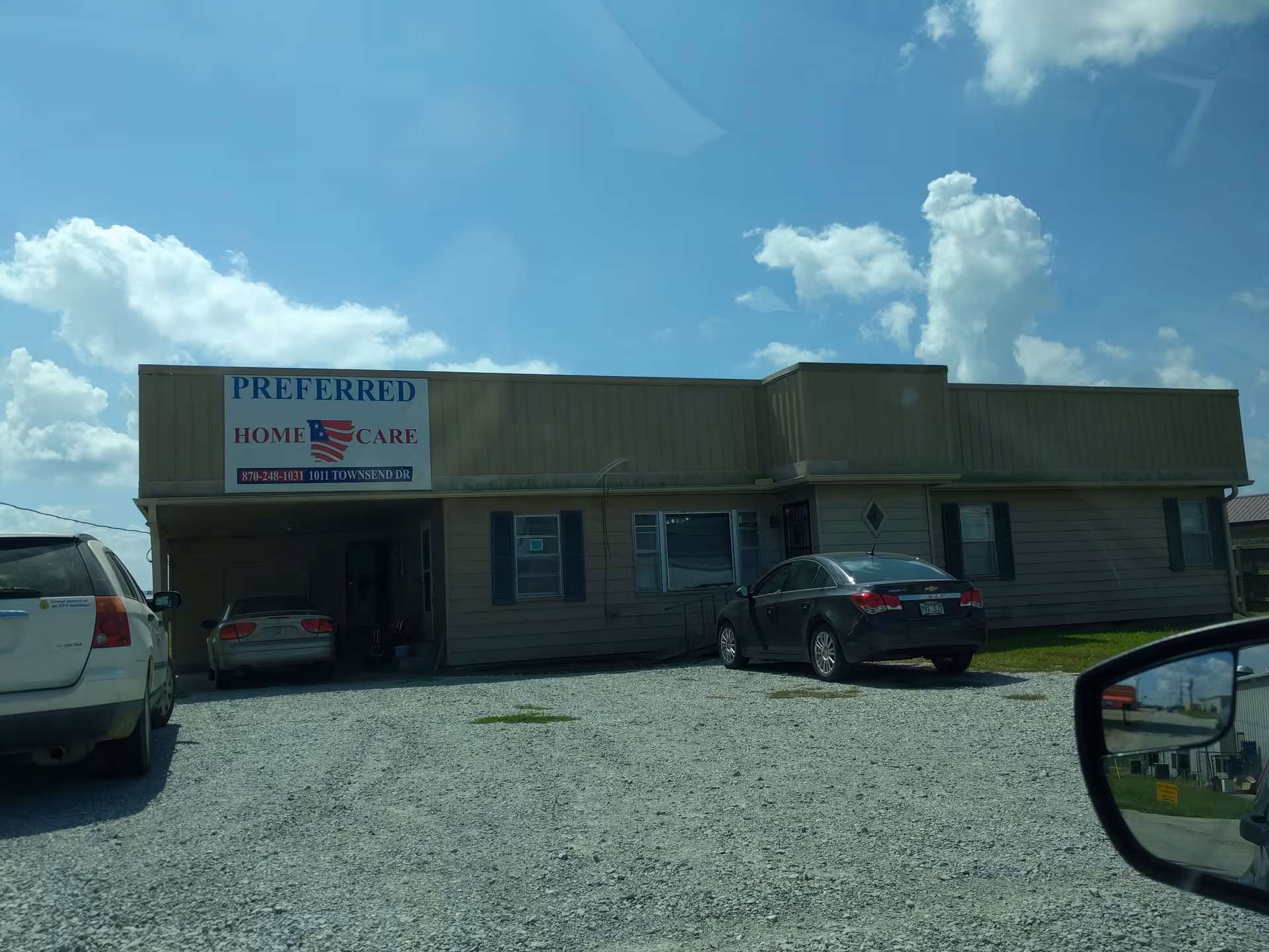 Single-story building with Preferred Home Care sign and parked cars outside.