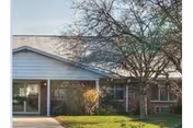 Front exterior view of Waters of Martinsville, single-story building with trees and glass doors.