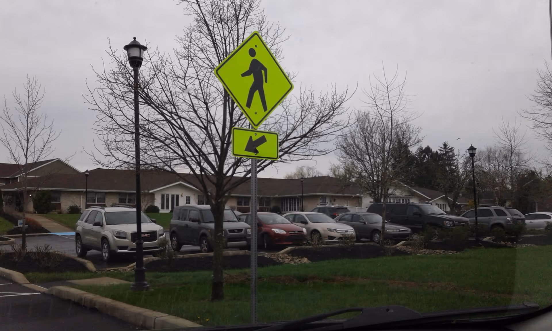 Parking lot in front of Buffalo Valley Personal Care with cars, trees, and street signs.