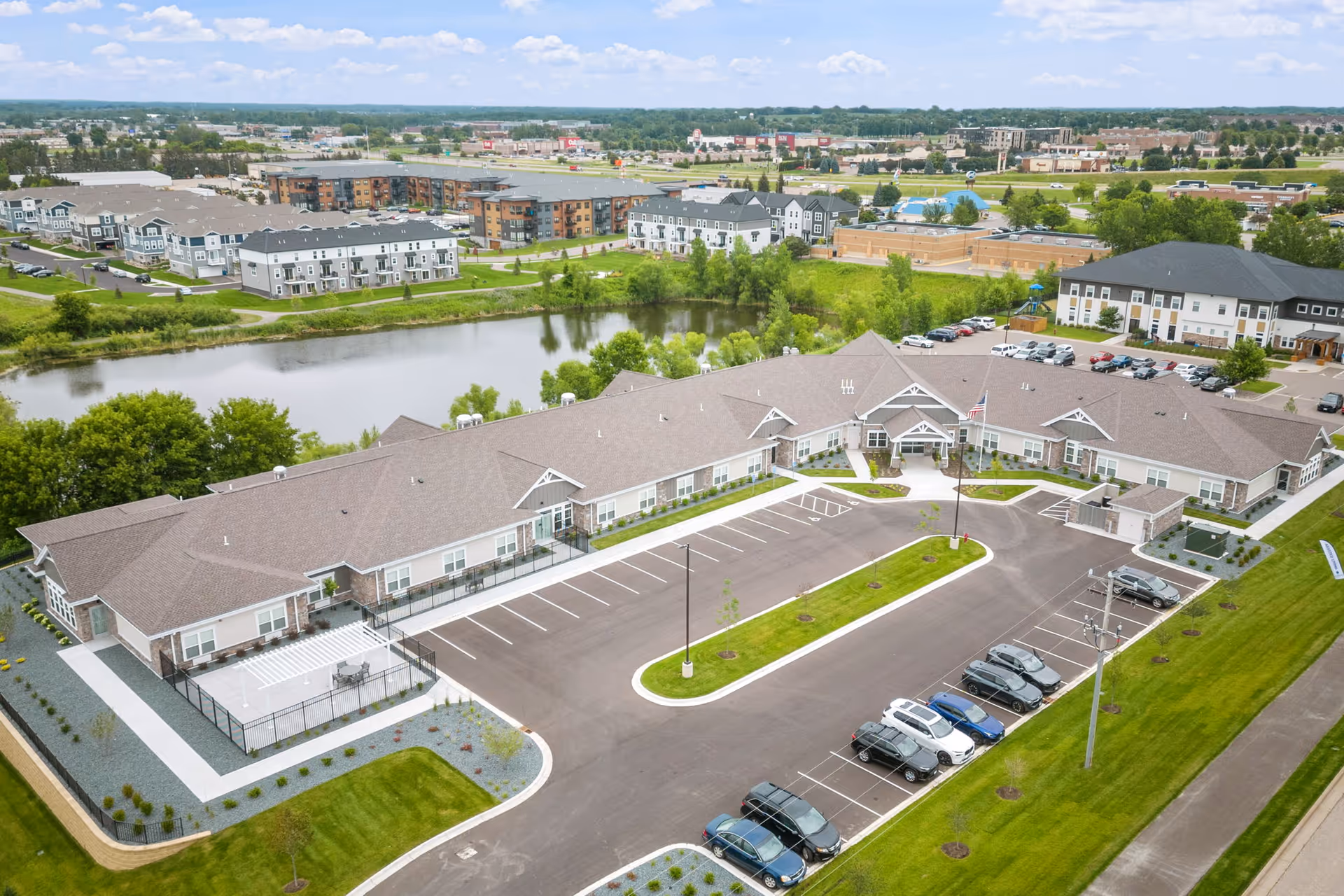 Aerial view of NorBella Senior Living Rogers campus with beige buildings and parking.