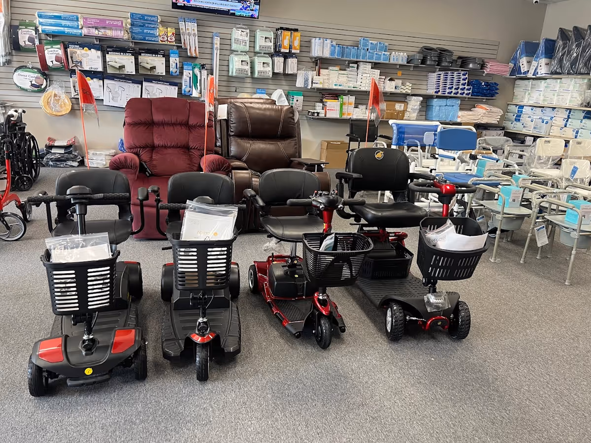 Interior showroom with mobility scooters, chairs, and medical supplies on shelves.