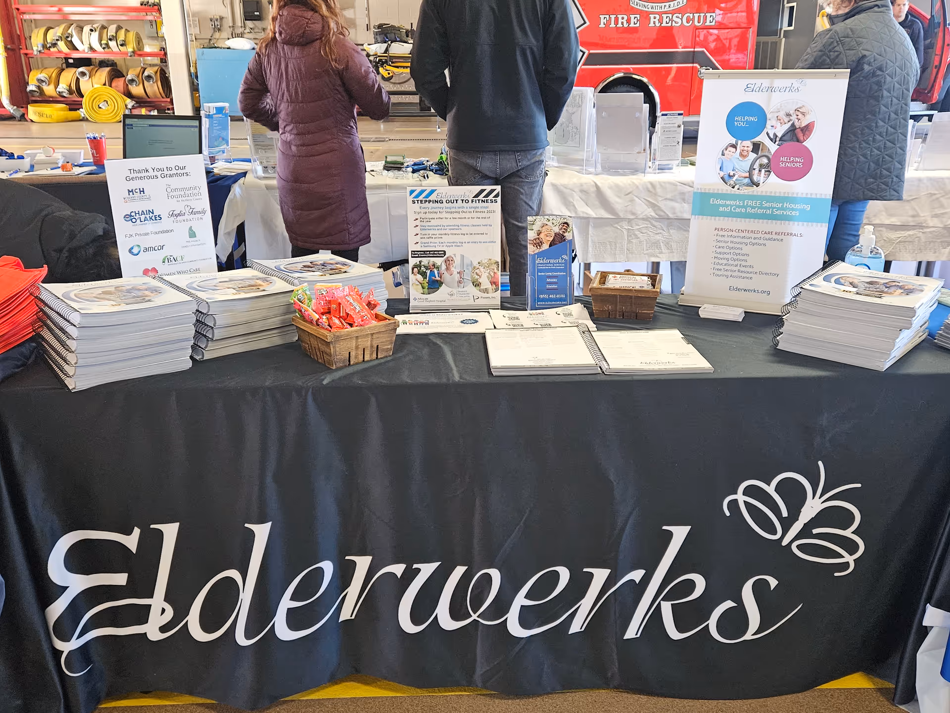 Elderwerks booth with brochures and staff at a senior care expo.