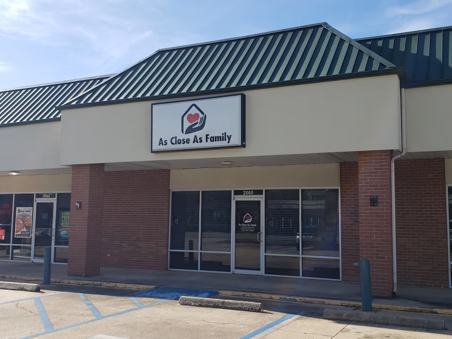 Front exterior of a brick building with the sign As Close As Family.