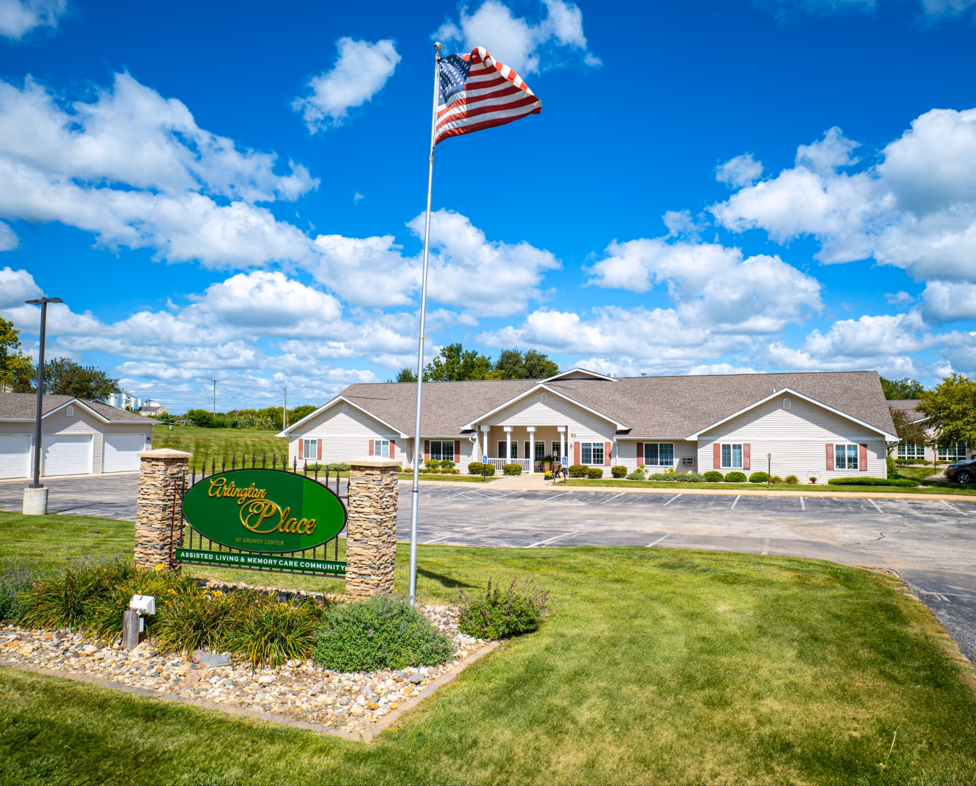 Arlington Place at Grundy Center exterior with flagpole, sign, and parking lot