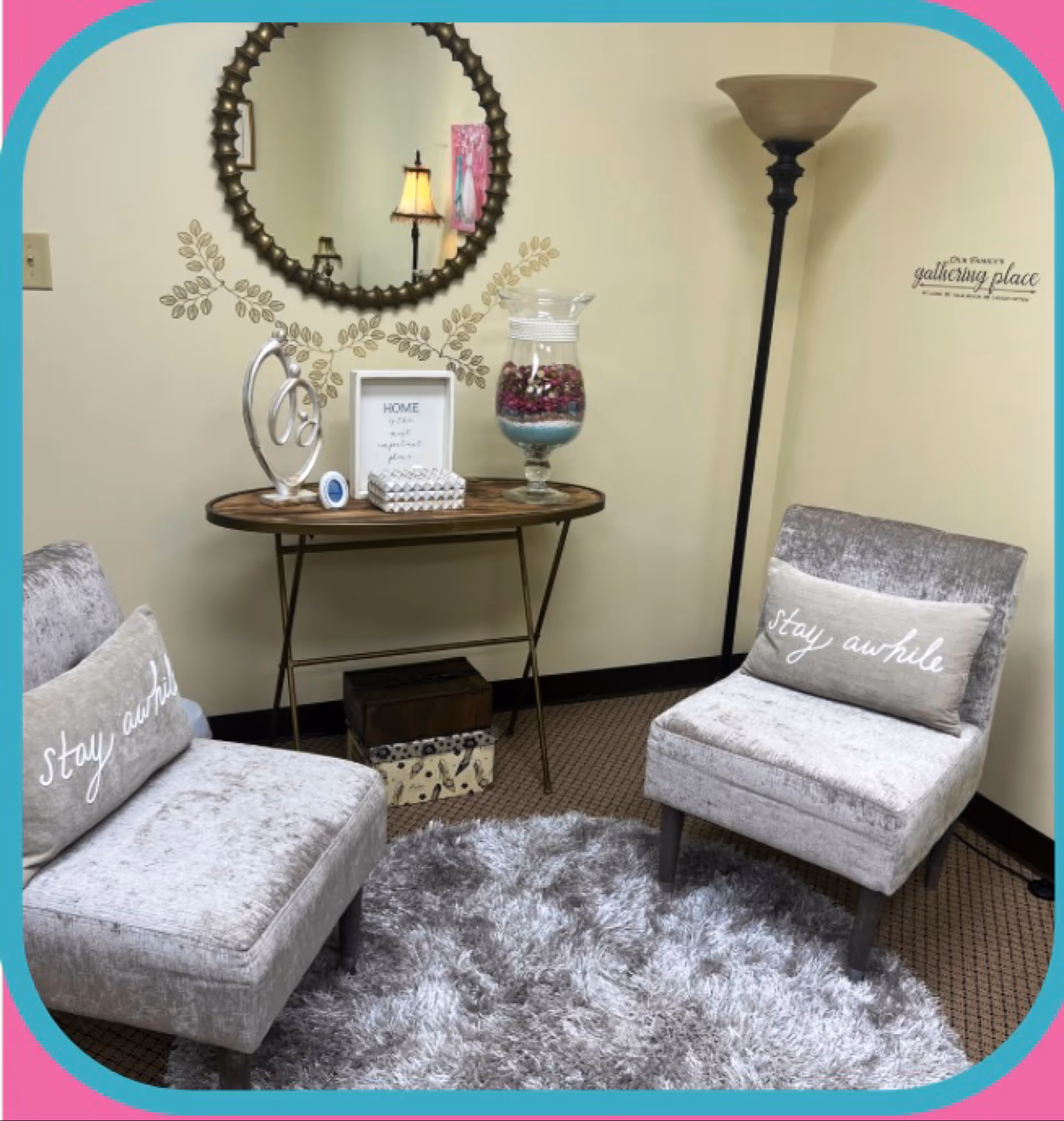 Cozy lobby seating with two gray chairs, a console table, and a fluffy rug.