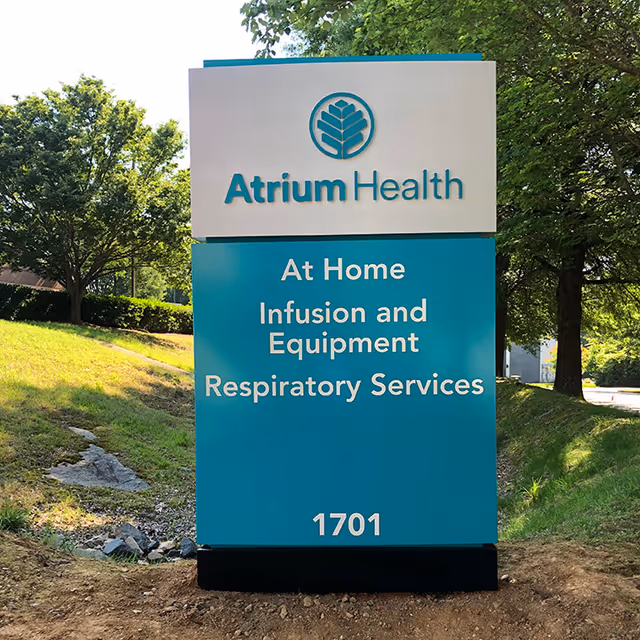 Outdoor Atrium Health sign for Infusion and Equipment Respiratory Services near trees.