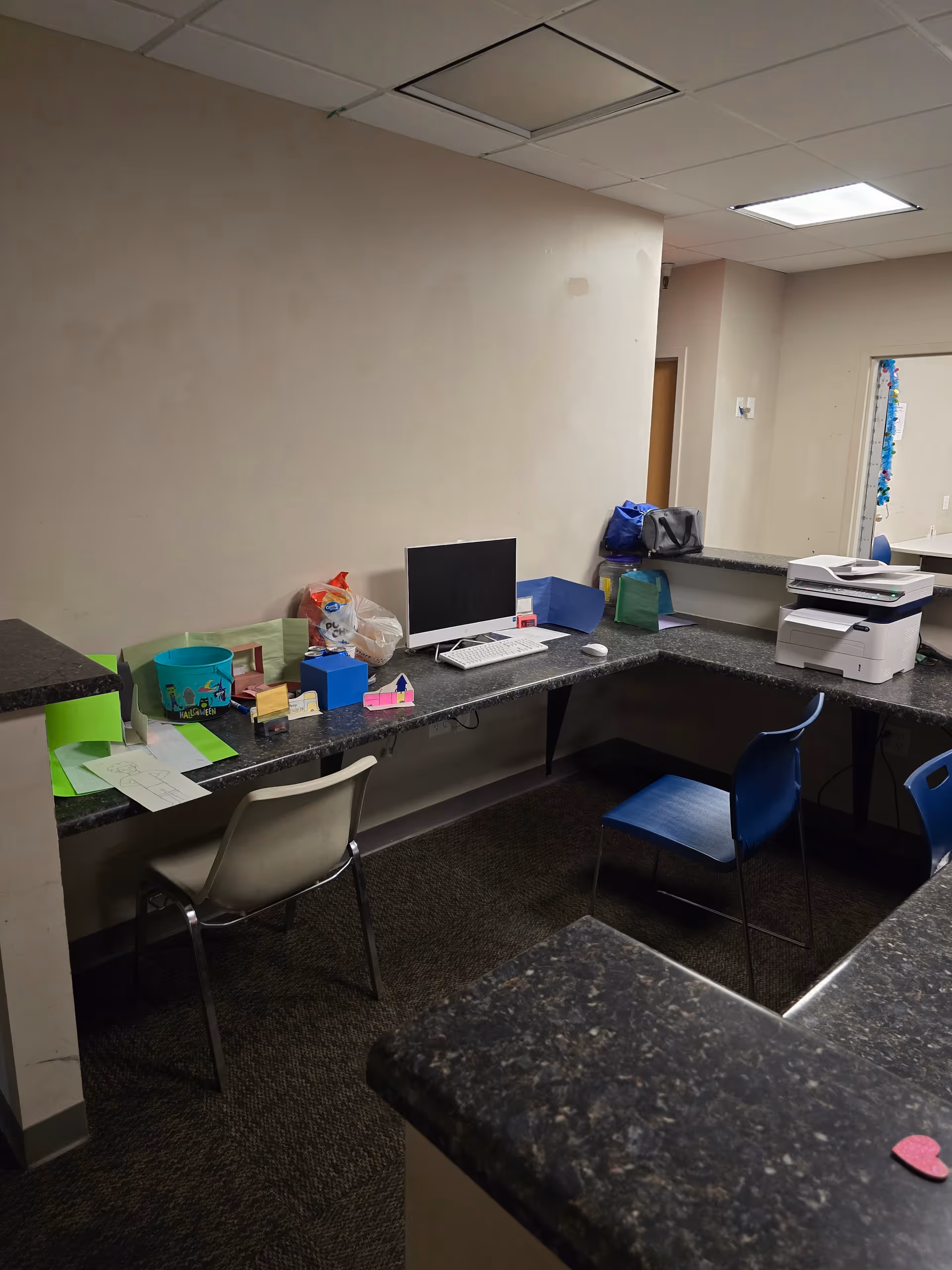 Interior office area with a long counter, computer, and printer.