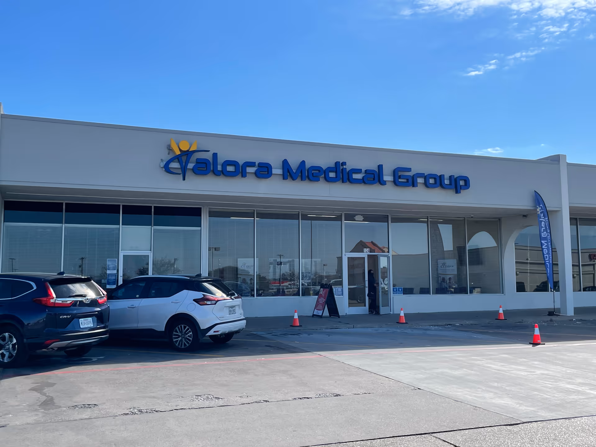 Exterior view of Valora Medical Group building with parked cars.