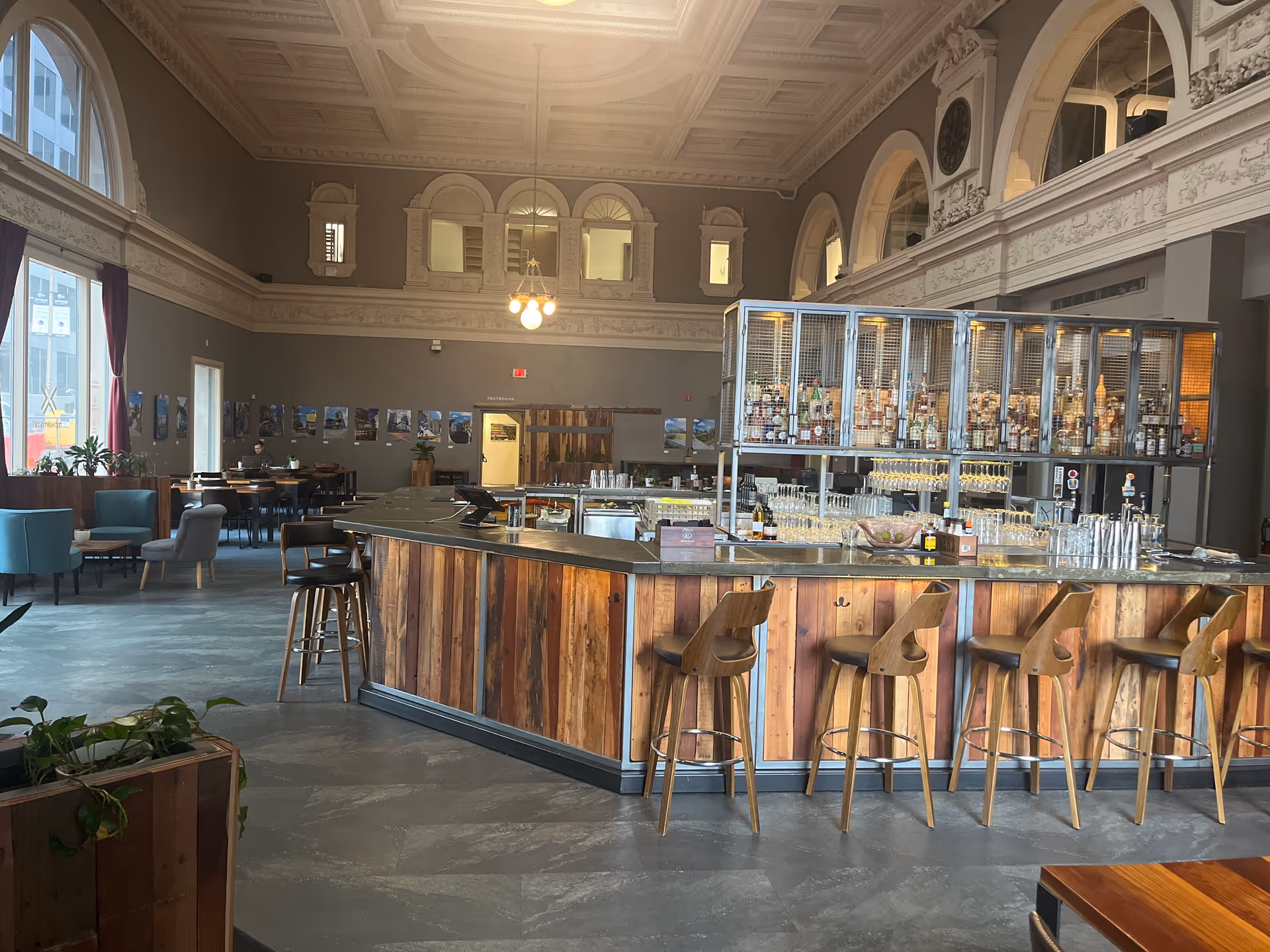 Elegant indoor bar area with wooden counter, stools, and ornate ceiling details.
