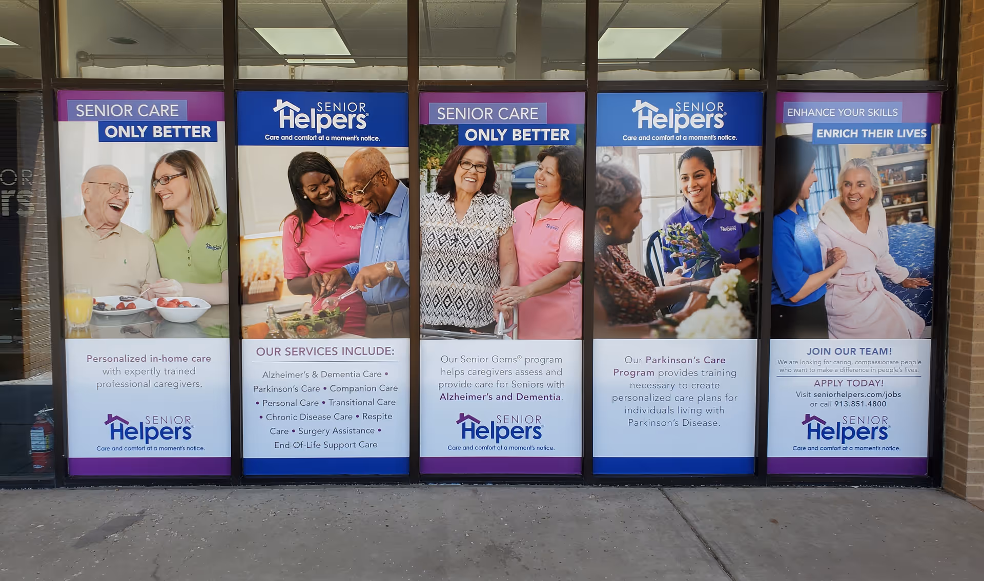 Front window display with multiple Senior Helpers posters for Johnson County senior care services.