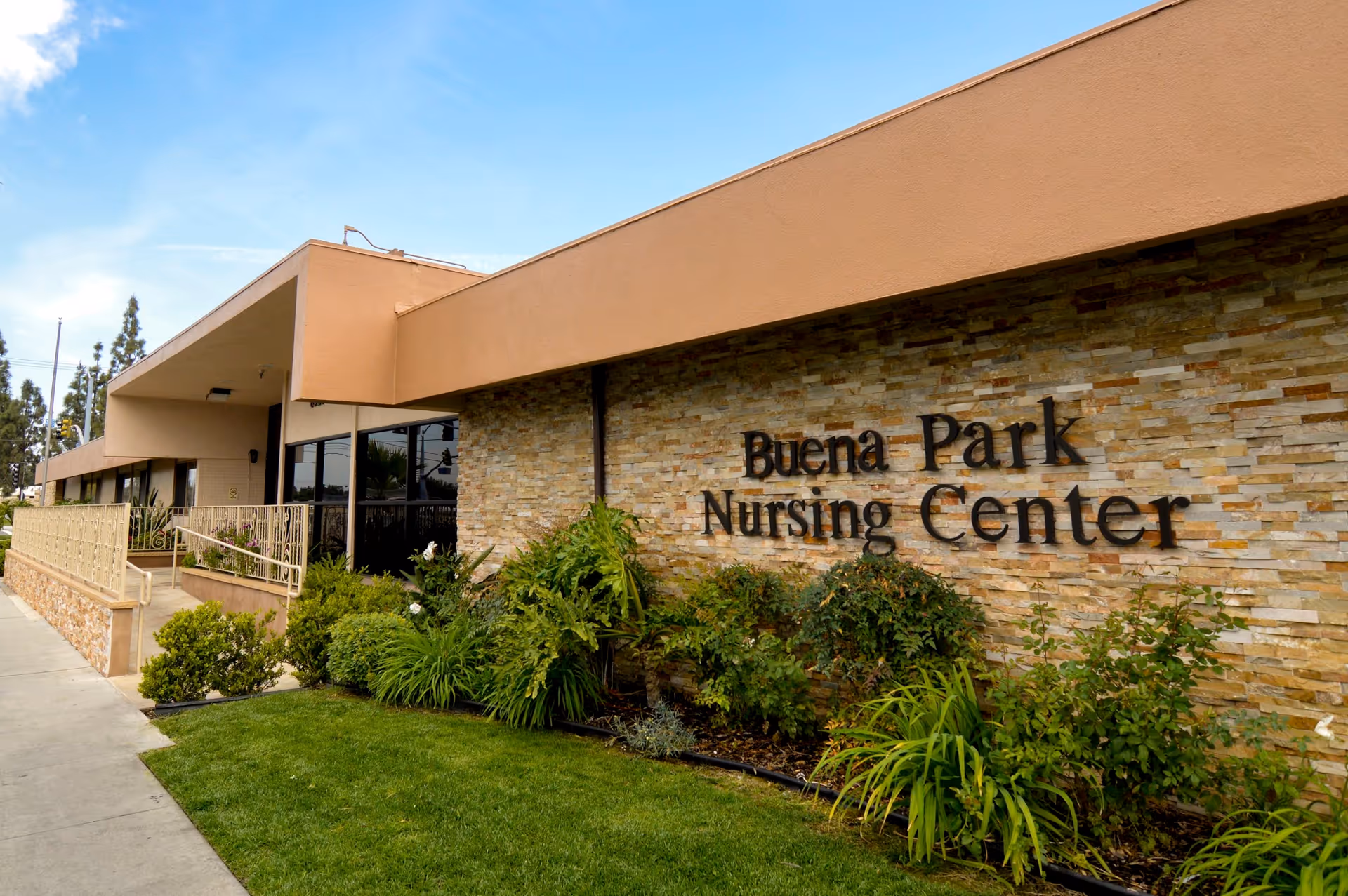 Exterior view of Buena Park Nursing Center with stone facade and landscaping