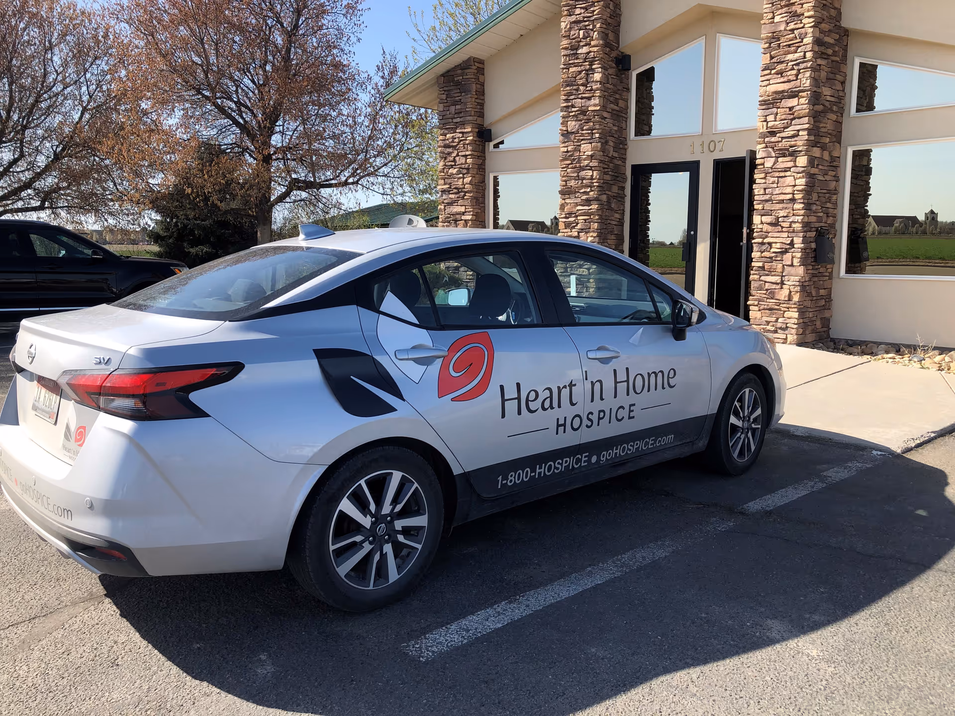 A Heart 'n Home Hospice car parked in front of the facility entrance.