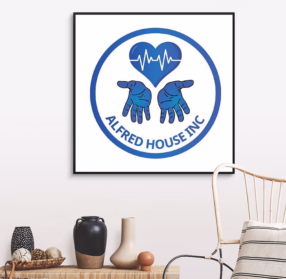 A framed Alfred House Inc logo hangs on a wall above decorative vases and a chair.