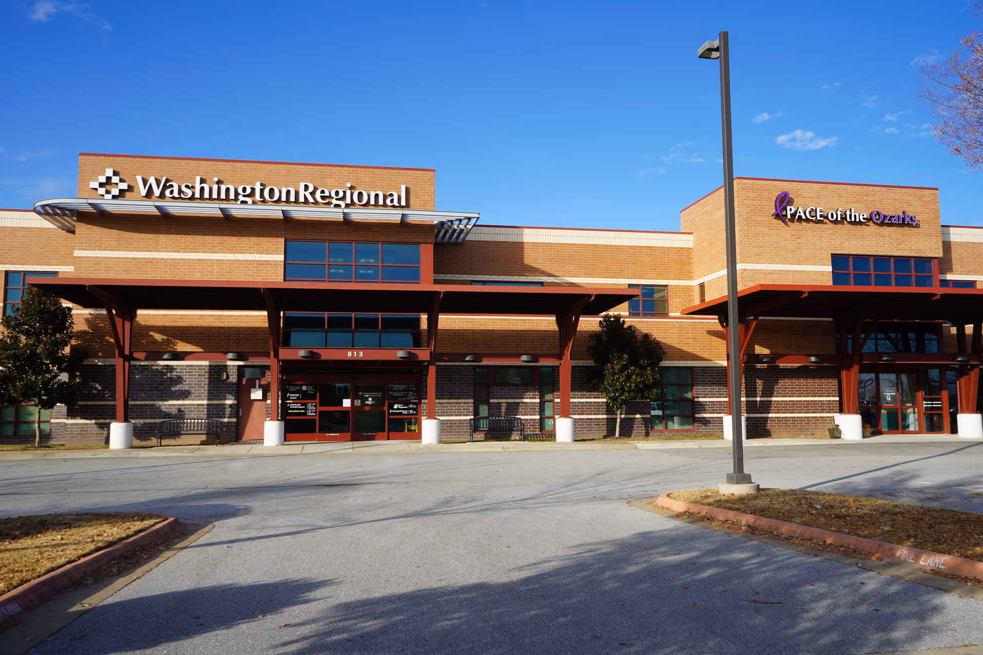Brick medical facility exterior with Washington Regional sign and PACE of the Ozarks entrance.