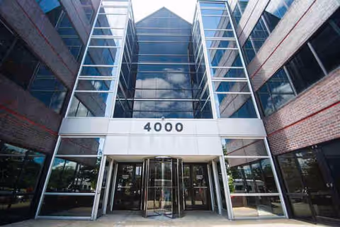 Modern glass-front building entrance with large windows and the number 4000 above doors.