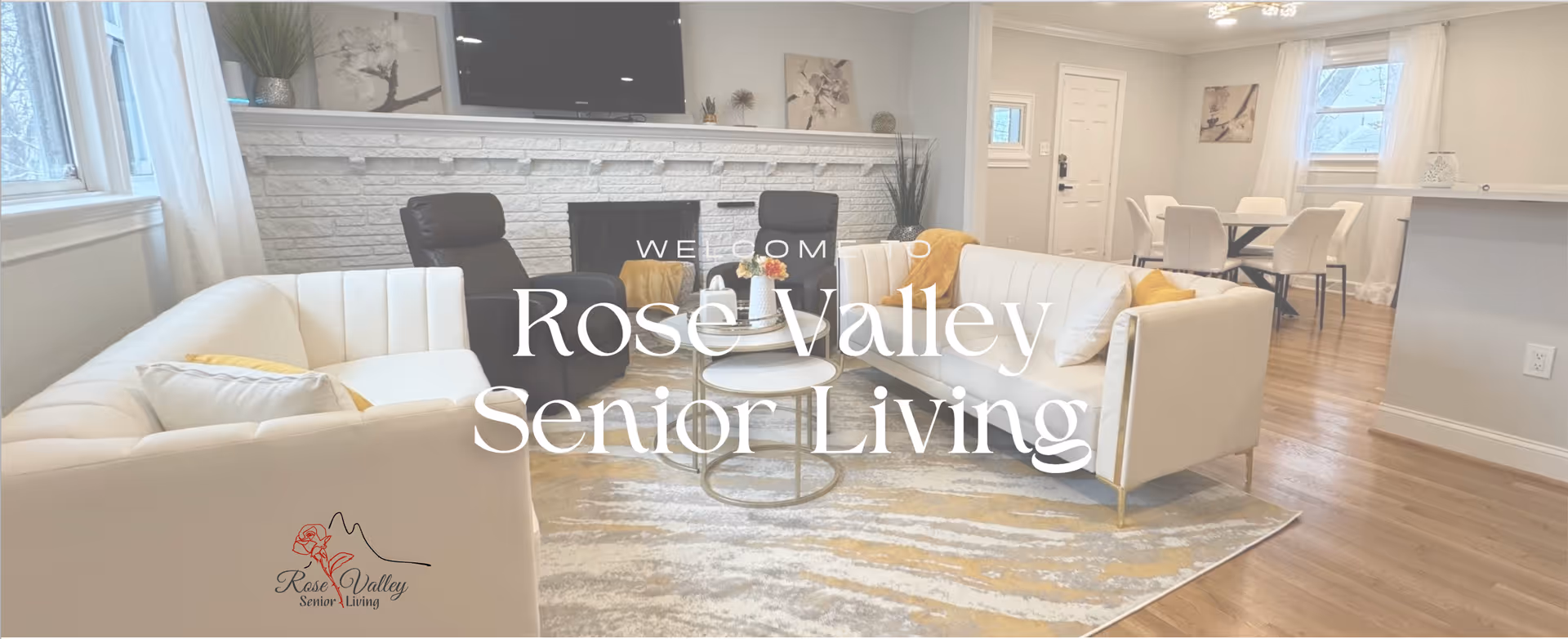 Bright modern living room lobby with white sofas, coffee tables, and a stone fireplace.