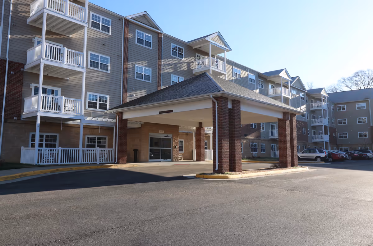 Exterior view of The Crossroads at Bon Air, a senior living building with a covered entrance.