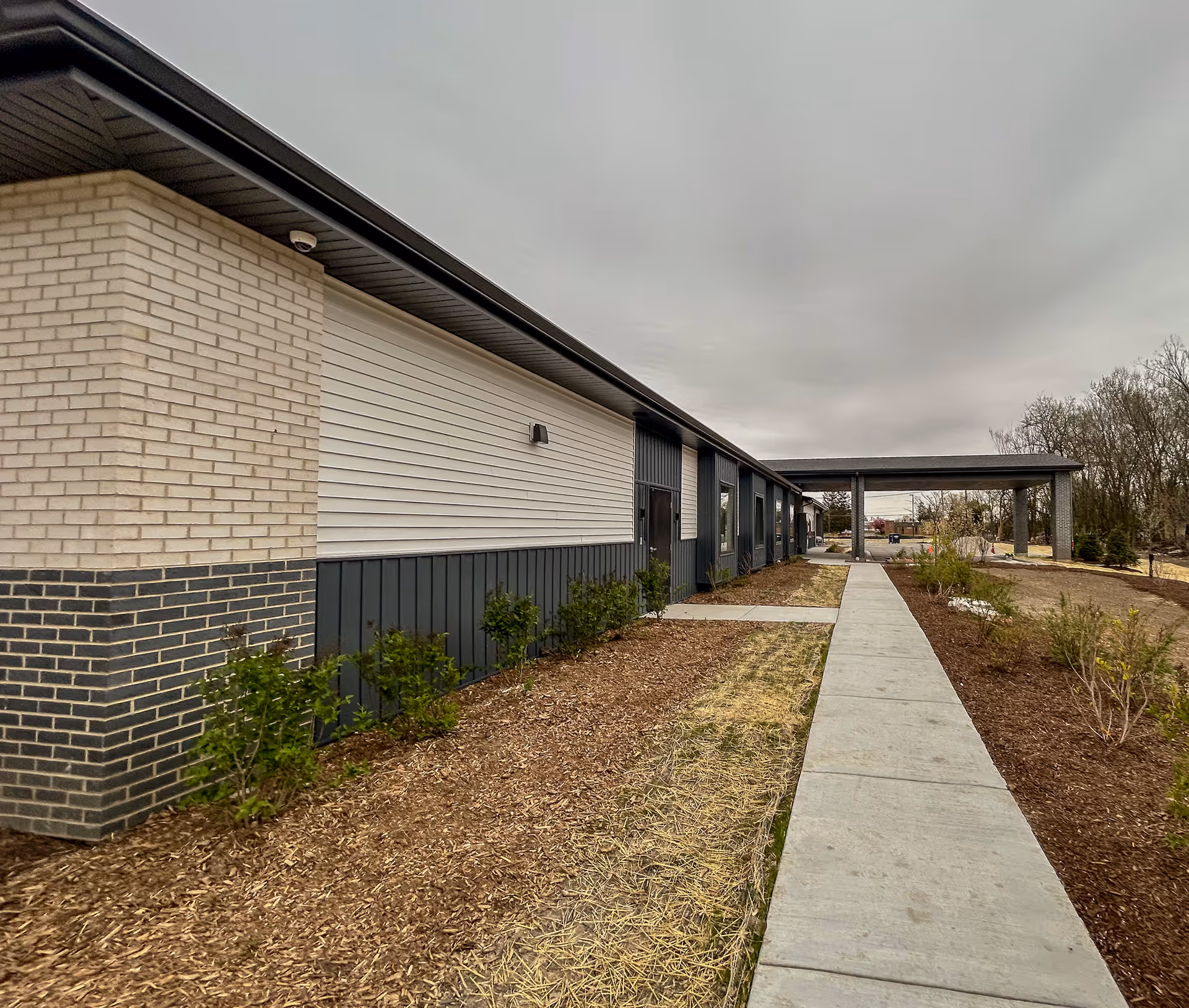 Exterior view of Oasis Hospice building with walkway and landscaped grounds