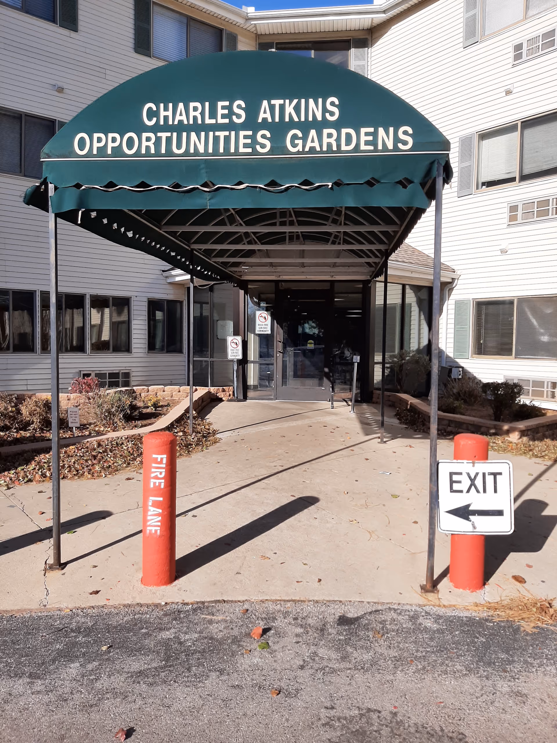 Entrance to Charles Atkins Opportunities Gardens with a green canopy over a walkway.