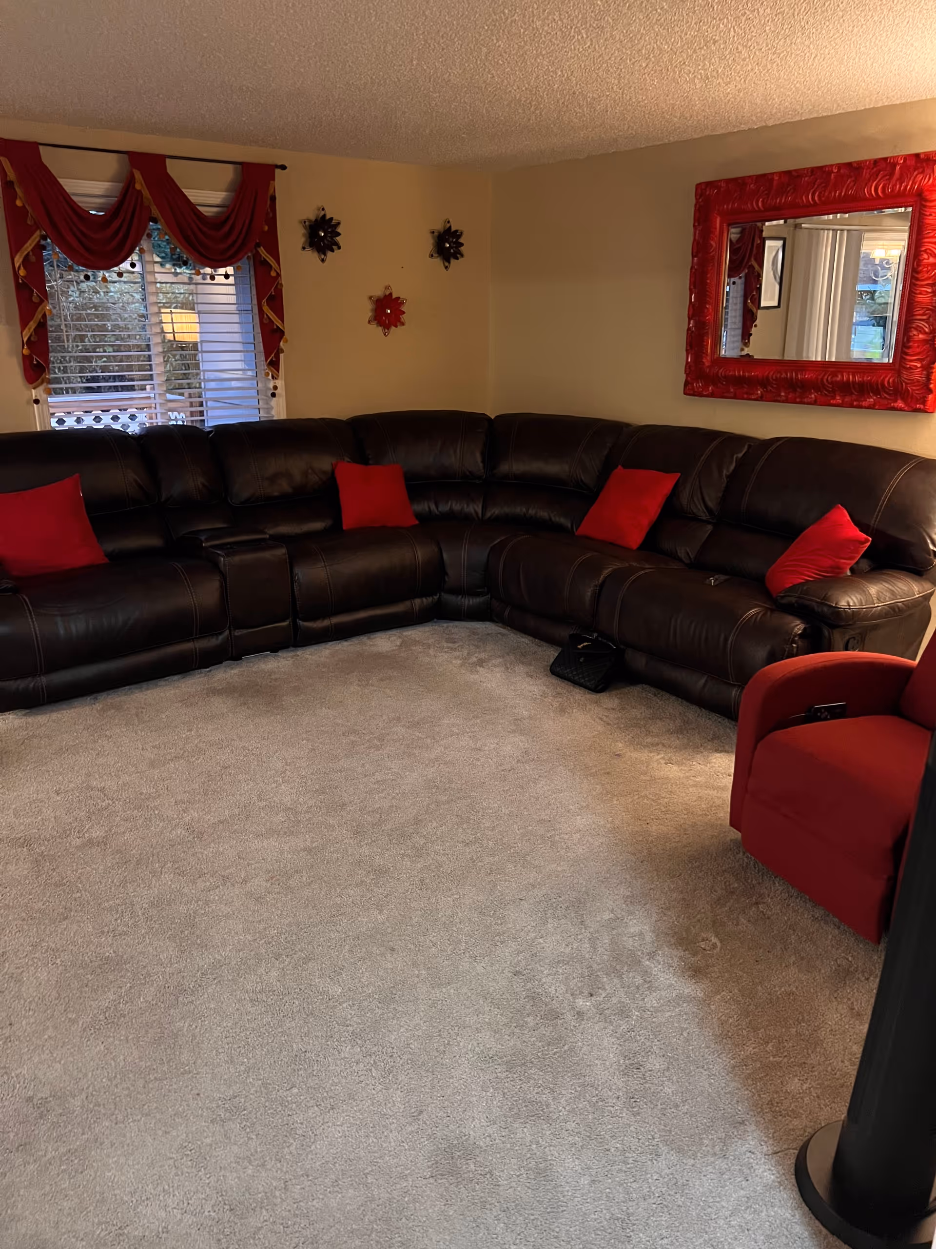 Cozy living room with a large leather sectional and red accents.