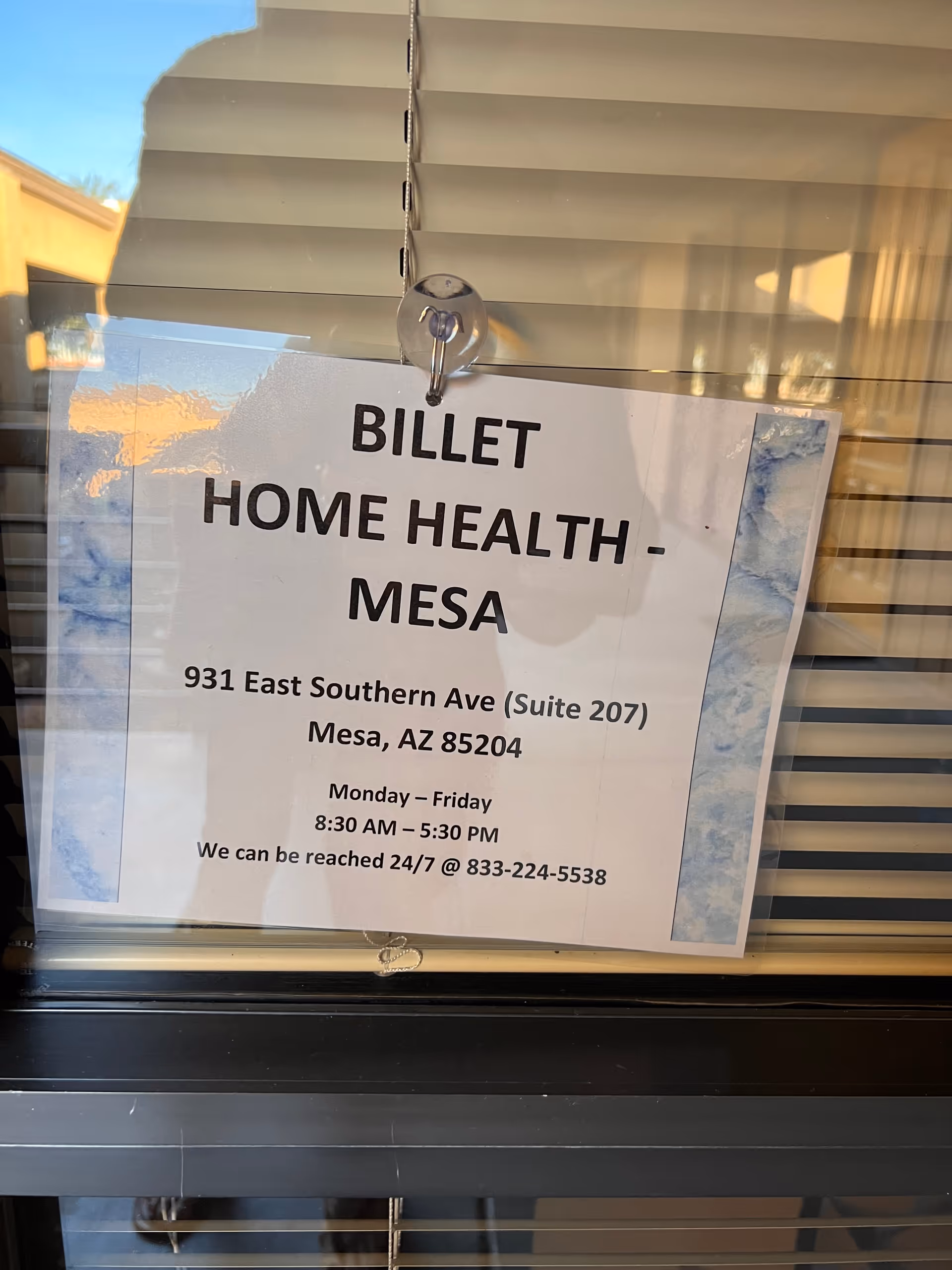 Sign reading Billet Home Health - Mesa hanging in front of window blinds.
