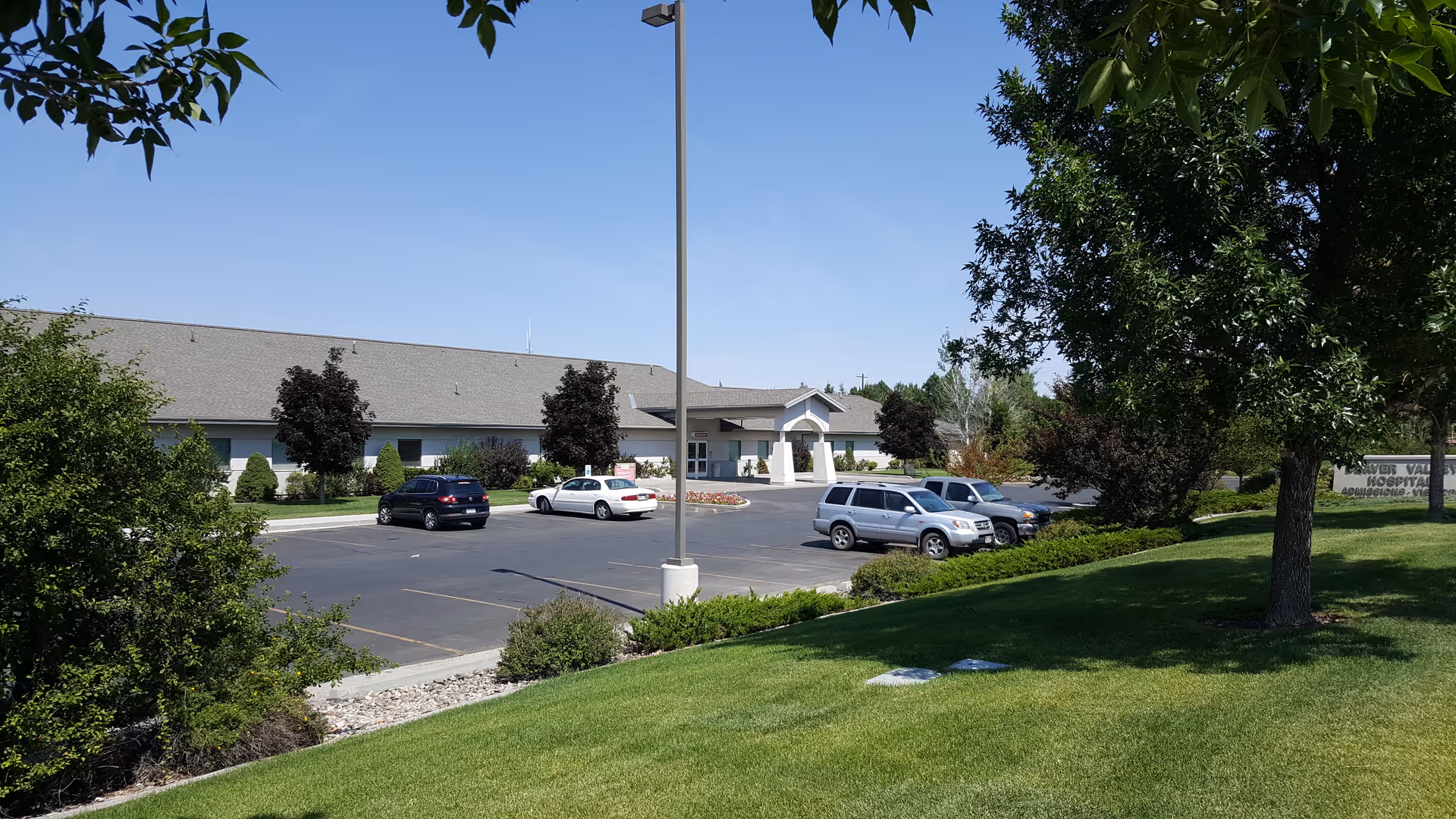 Exterior view of Beaver Valley Hospital with parking lot and green landscaping