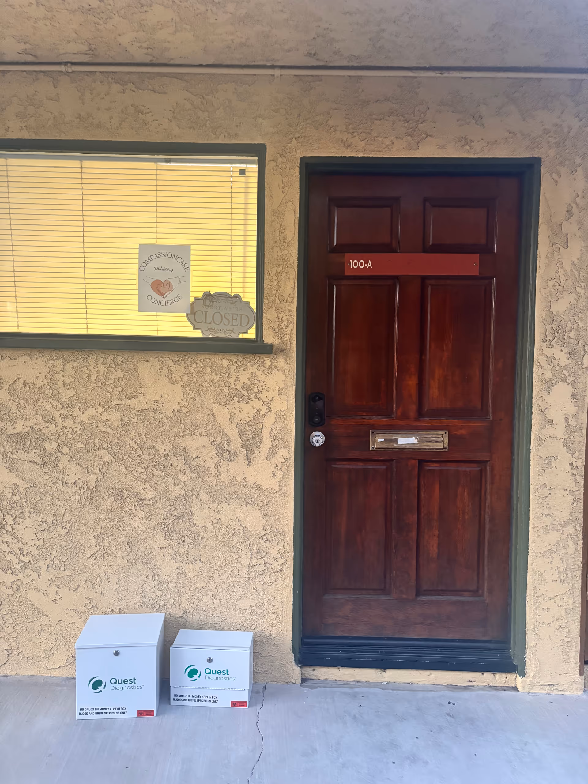 Exterior front entrance with a wooden door labeled 100-A and a window with blinds.