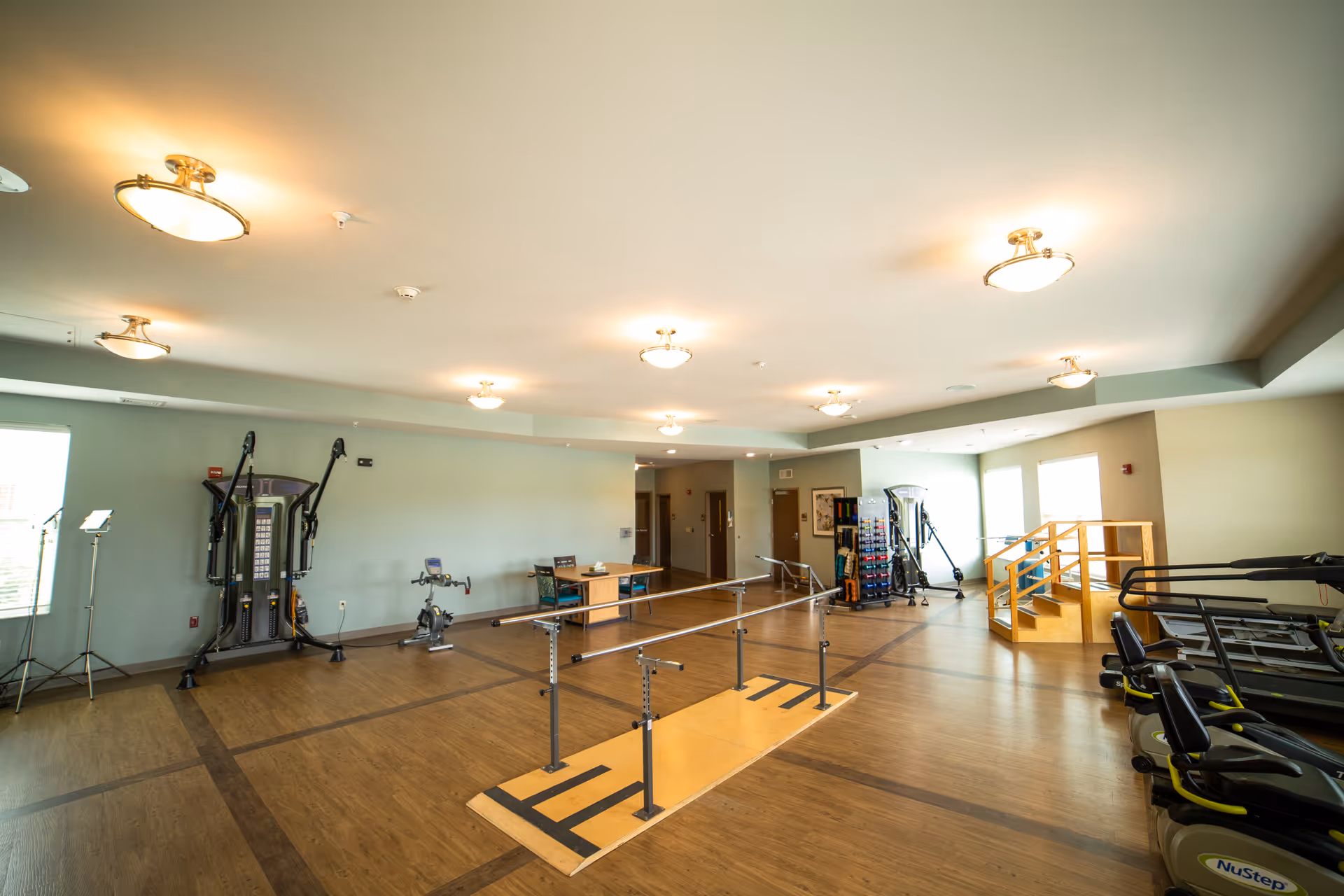 Auburn Village fitness center interior with treadmills, weight machines, and parallel bars.