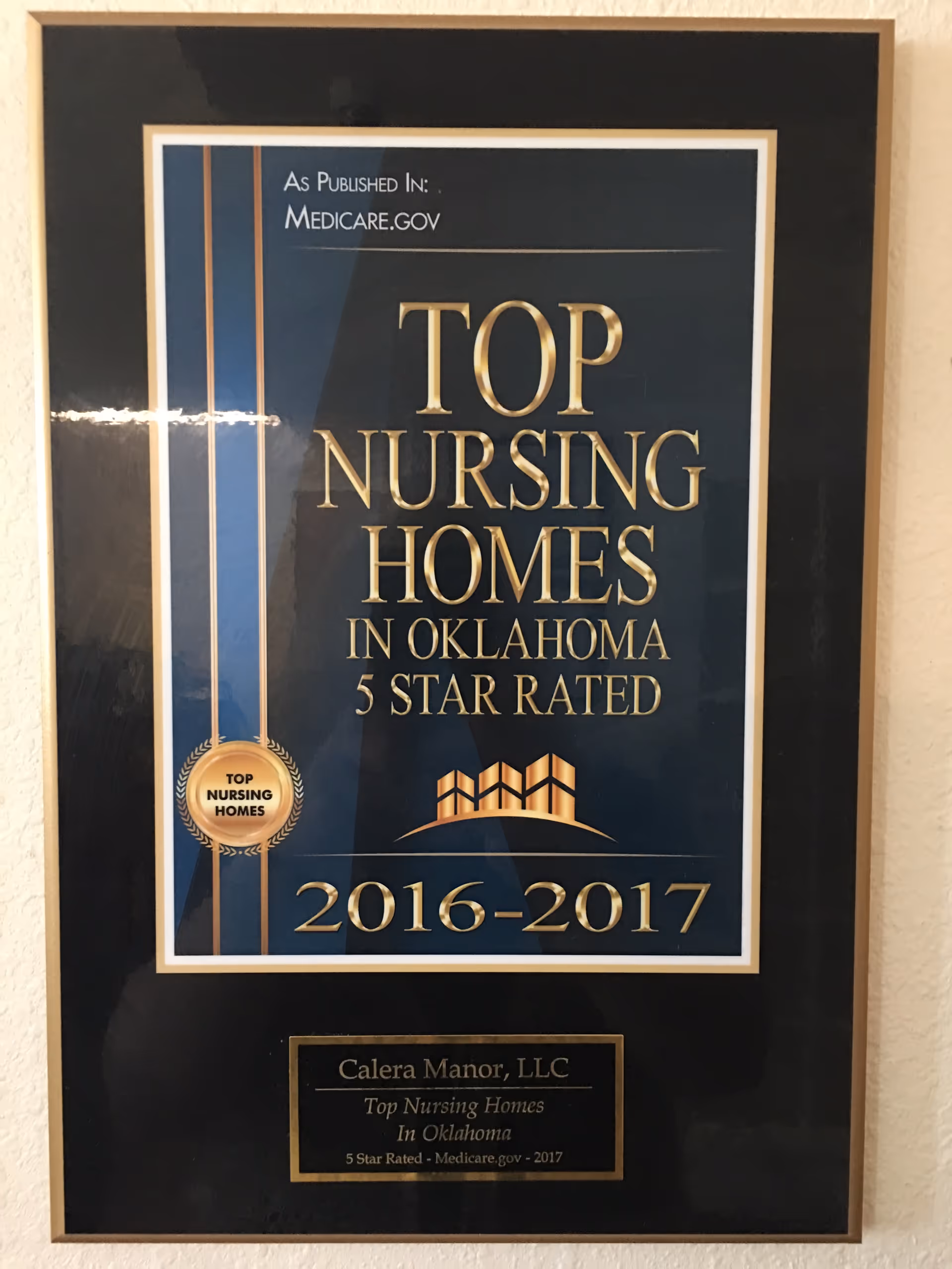 Framed award plaque on a wall recognizing Calera Manor as top Oklahoma nursing home.