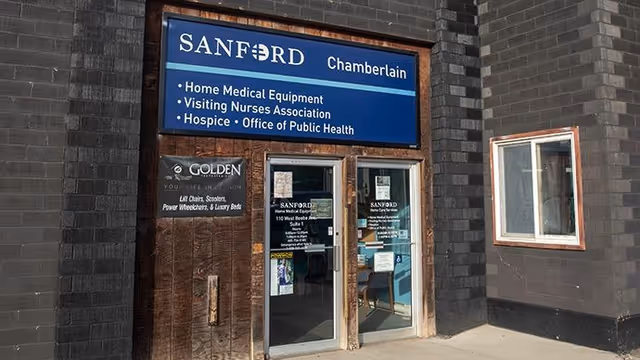 Brick building entrance with Sanford Chamberlain signage and glass doors.