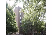 Exterior view of Weinberg Gardens, a brick senior living building with trees.
