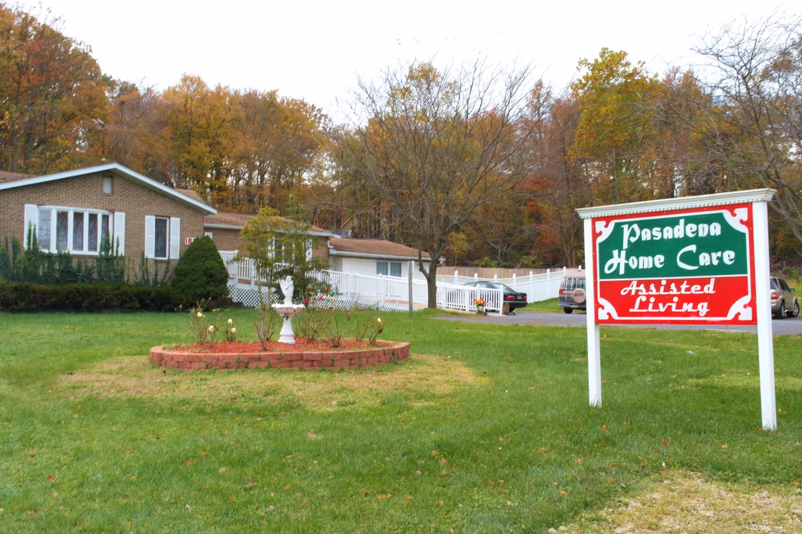Exterior view of Pasadena Home Care Assisted Living sign with building and trees