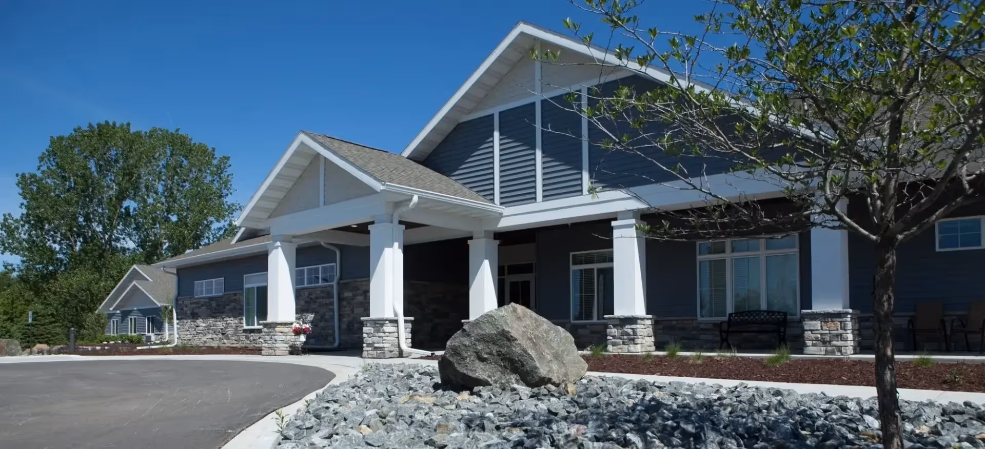 Exterior view of Bay Harbor Memory Care & Assisted Living building with a covered entrance.