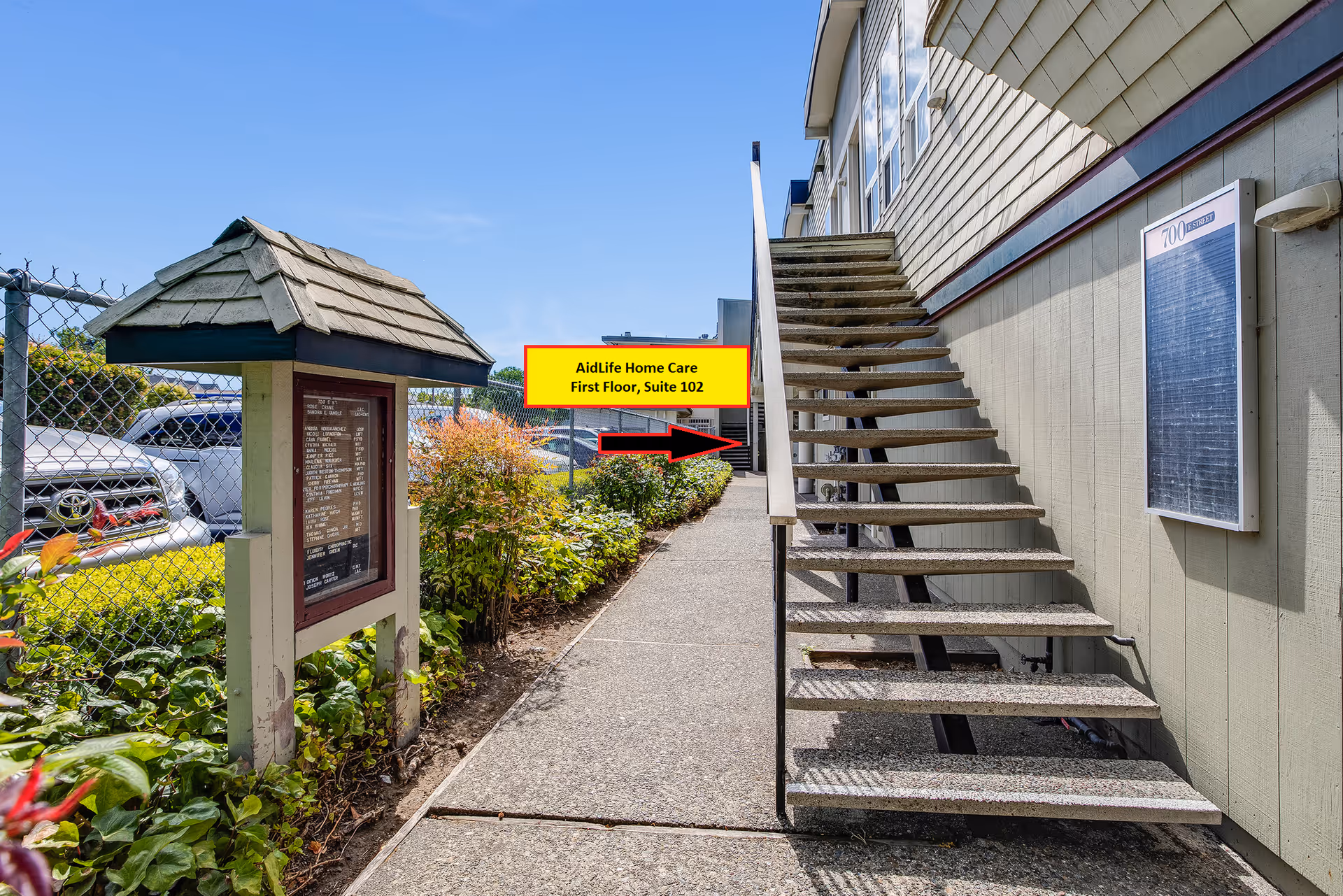 Exterior view of a senior care building with a metal stairway and AidLife sign