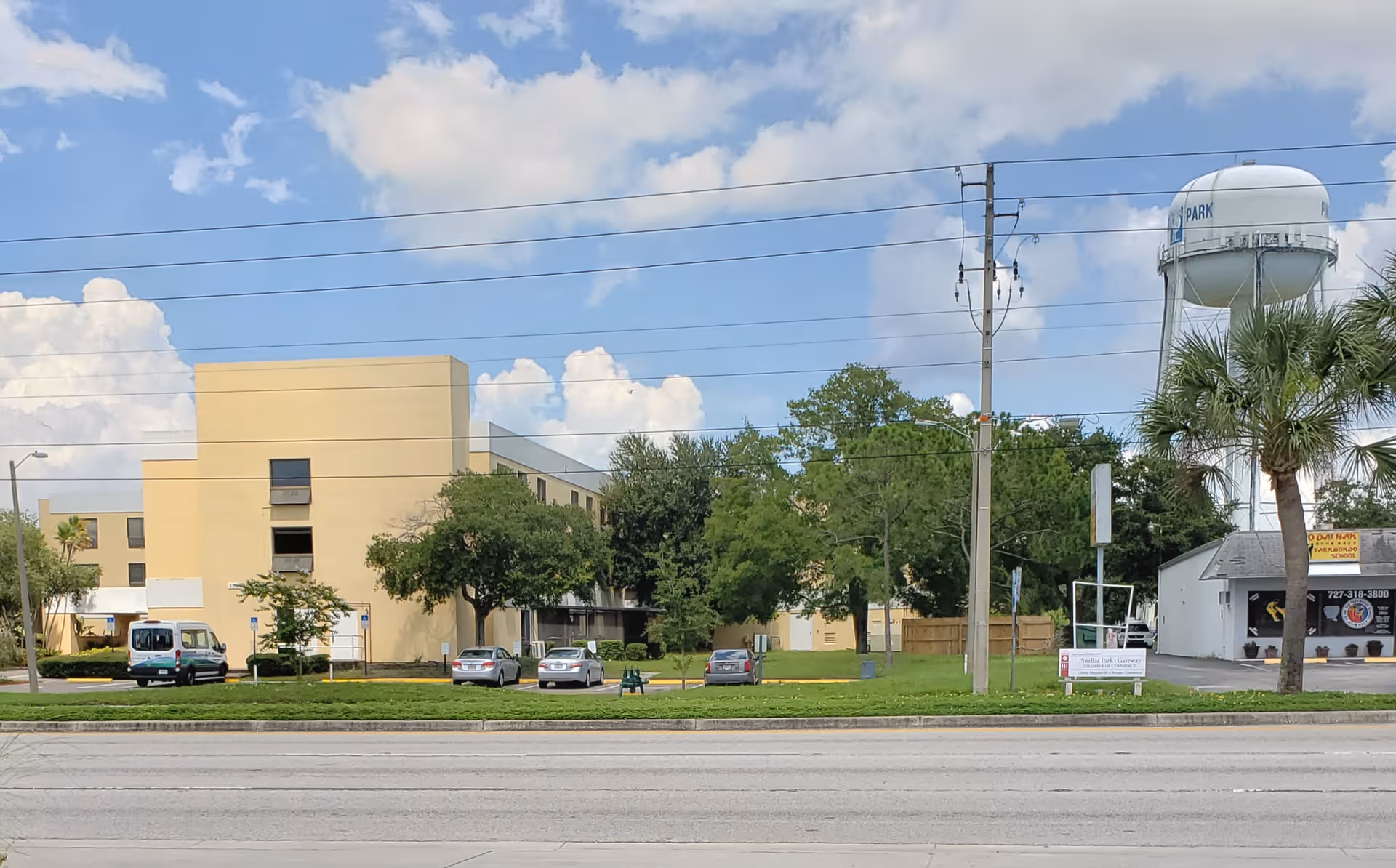Exterior view of Pinellas Park Post-Acute and Rehabilitation Center with trees and parked cars.