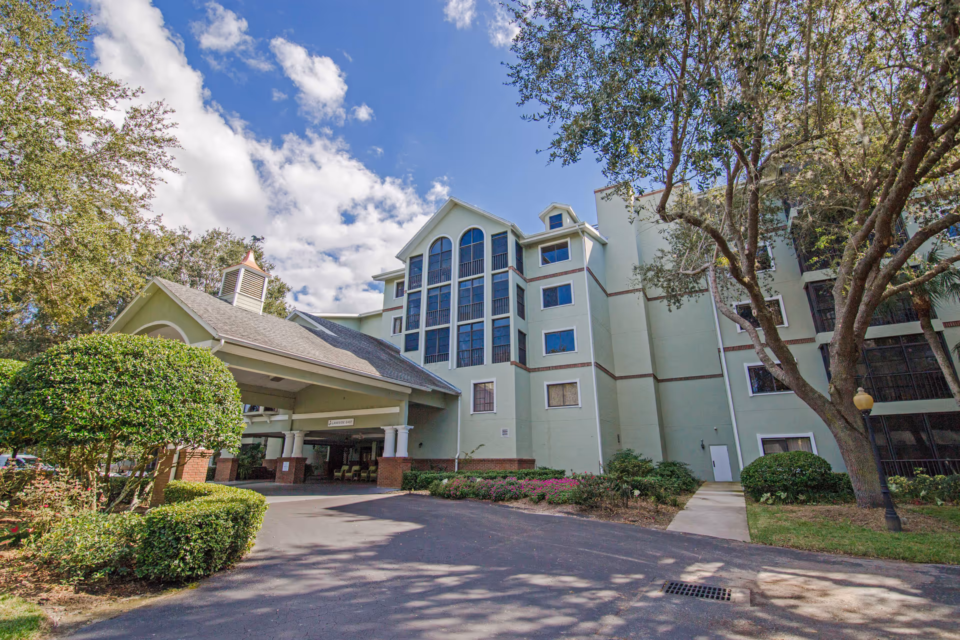 Lake Port Square senior living facility exterior with a covered entrance and landscaped grounds.