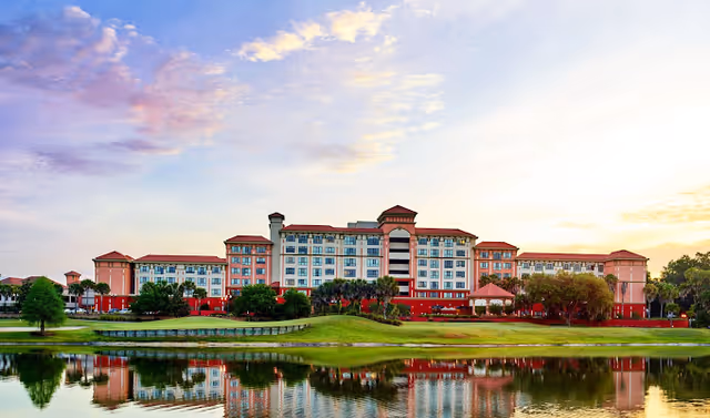 Front view of Freedom Pointe senior living campus along a reflective lake.
