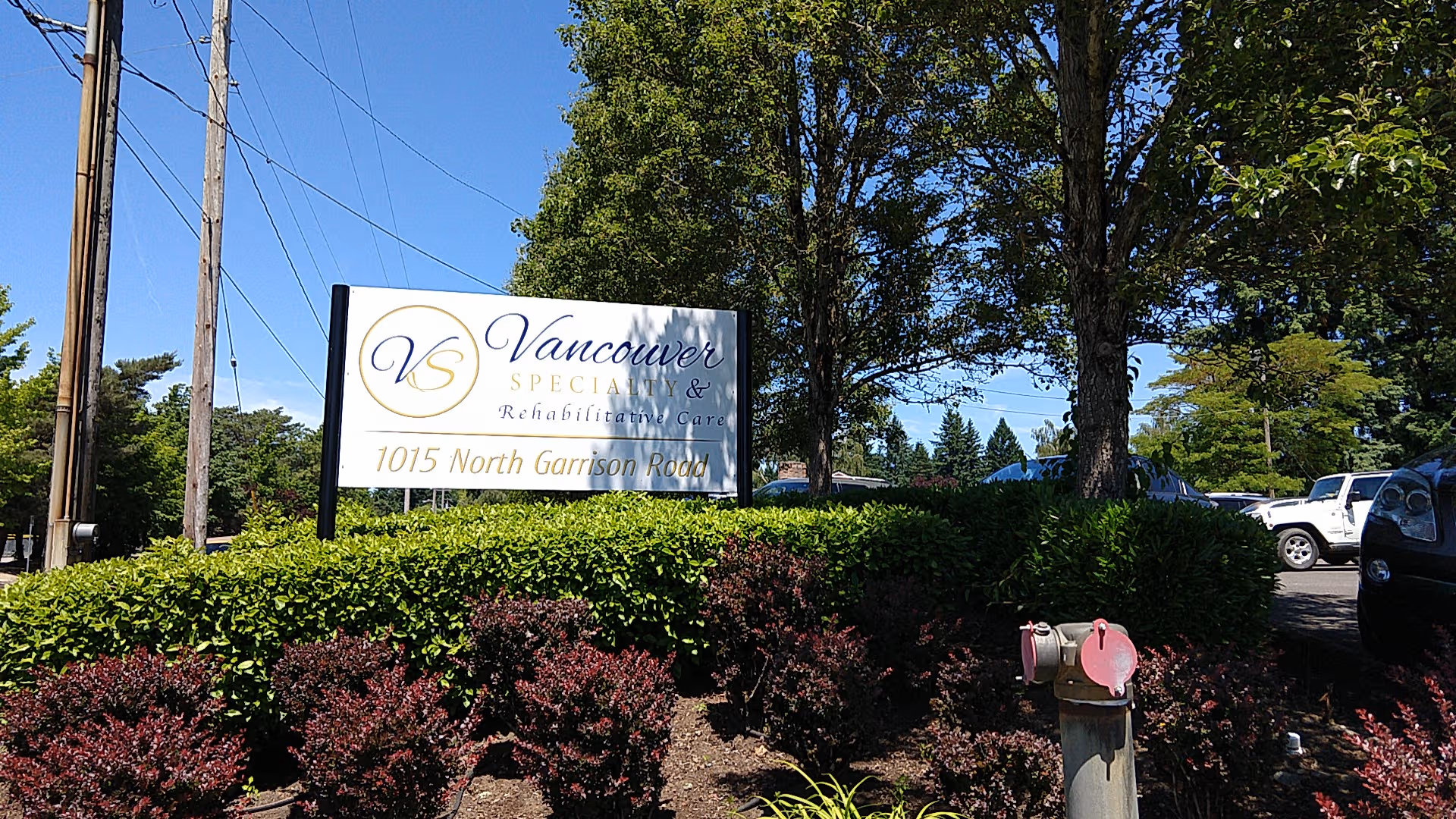 Front outdoor sign for Vancouver Specialty and Rehabilitative Care with trees