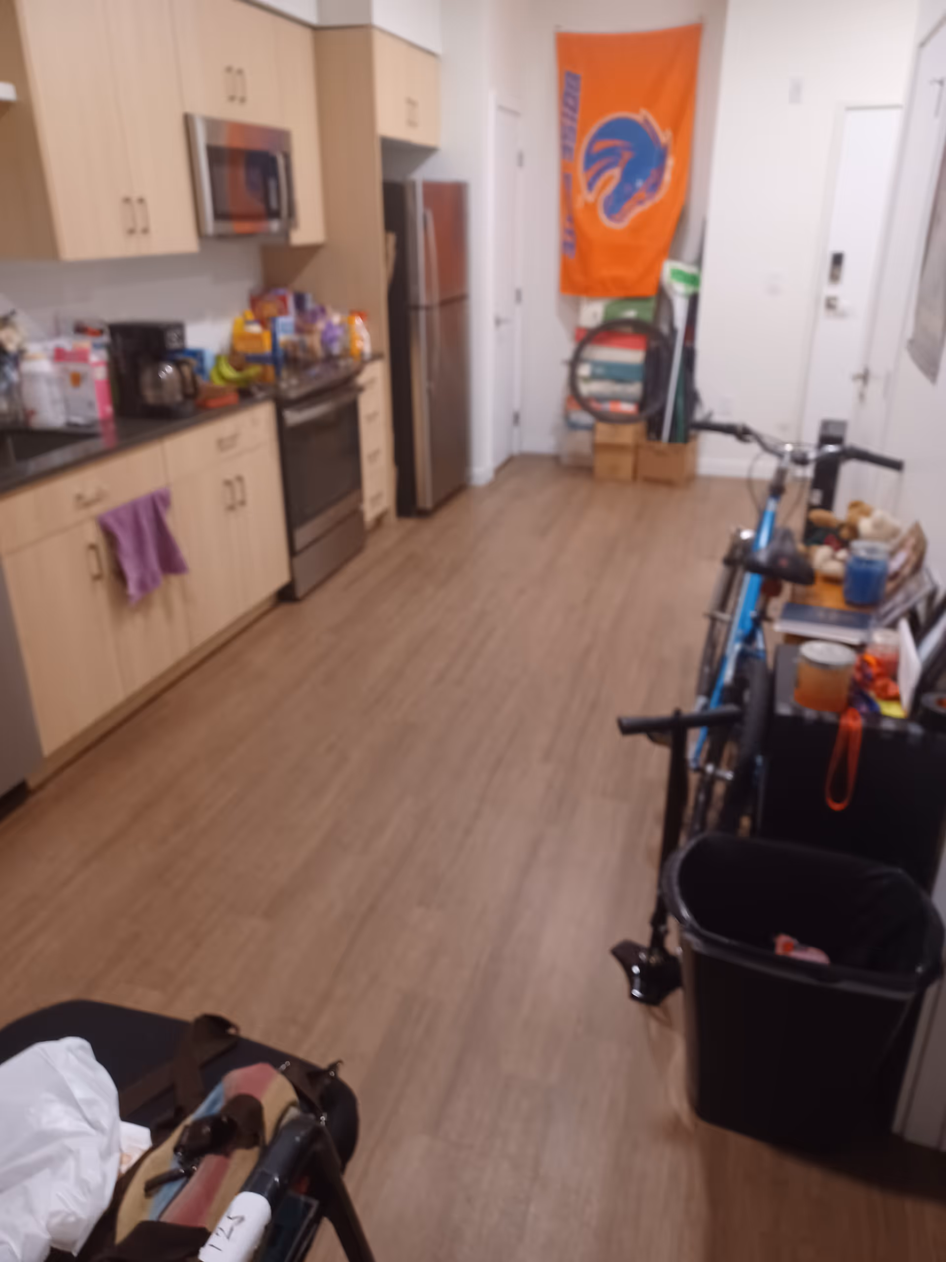 Interior kitchen in a senior care facility with appliances, cabinets, and clutter.