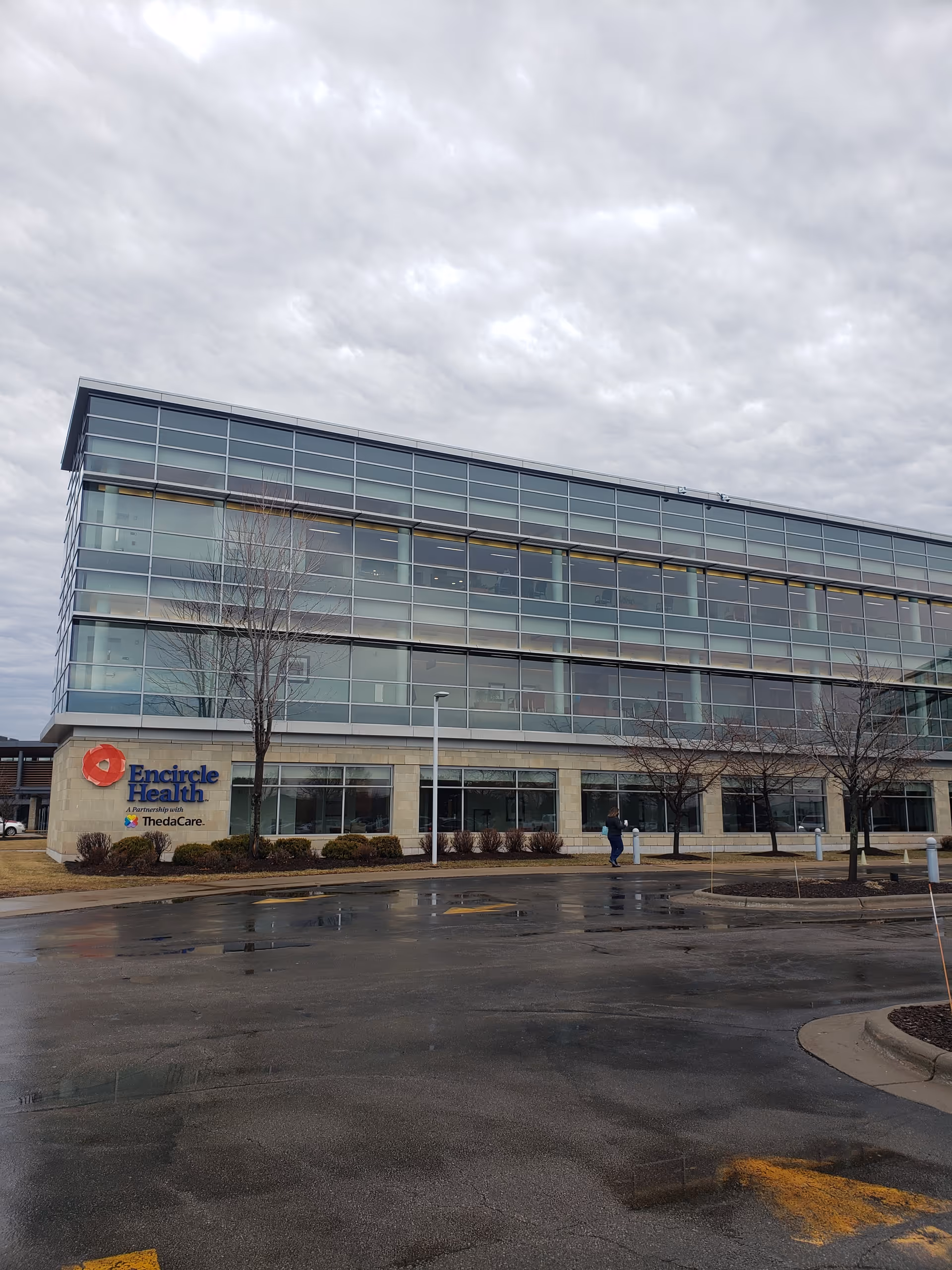 Exterior view of Encircle Health building with glass facade and a parking lot.