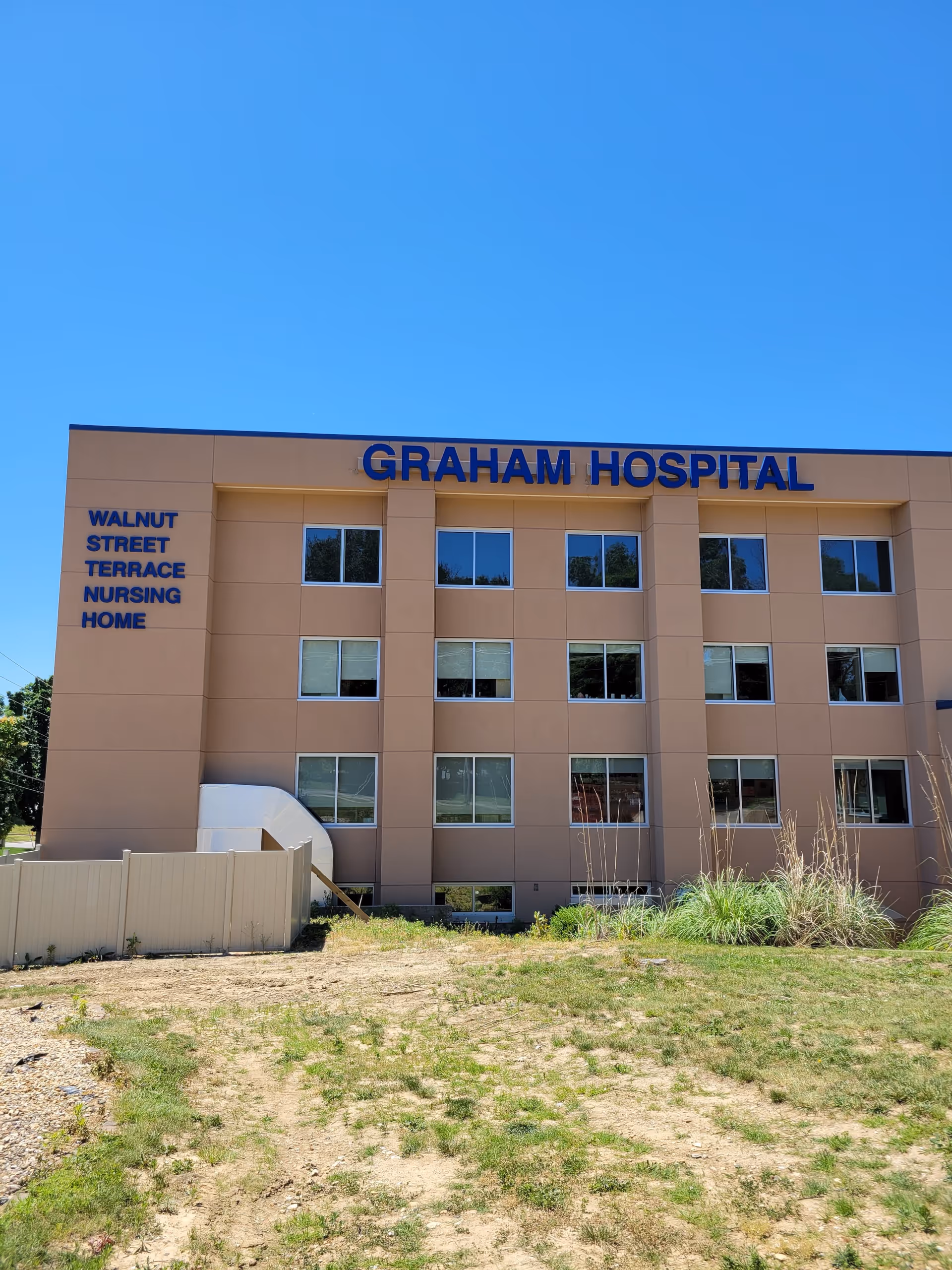 Front facade of Graham Hospital exterior with Walnut Street Terrace Nursing Home signage on left.
