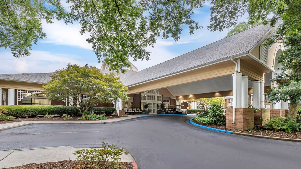 Exterior view of Brookdale Chambrel Roswell with covered entrance and drive, green landscaping.