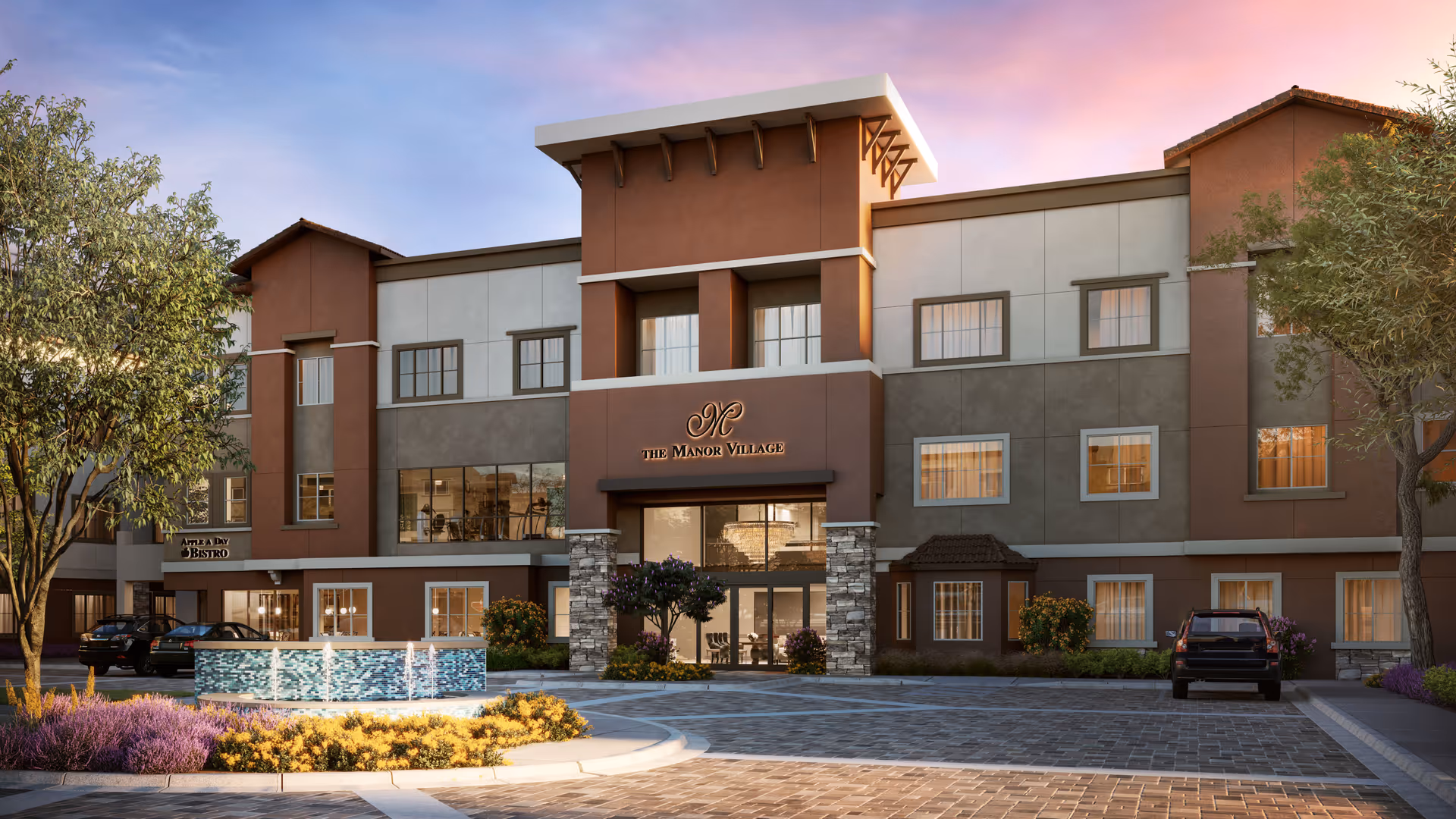Exterior view of The Manor Village senior living facility at Desert Ridge during sunset, showing a three-story building with multiple windows, a central entrance with stone pillars, a water fountain in front, landscaped plants, and parked cars.
